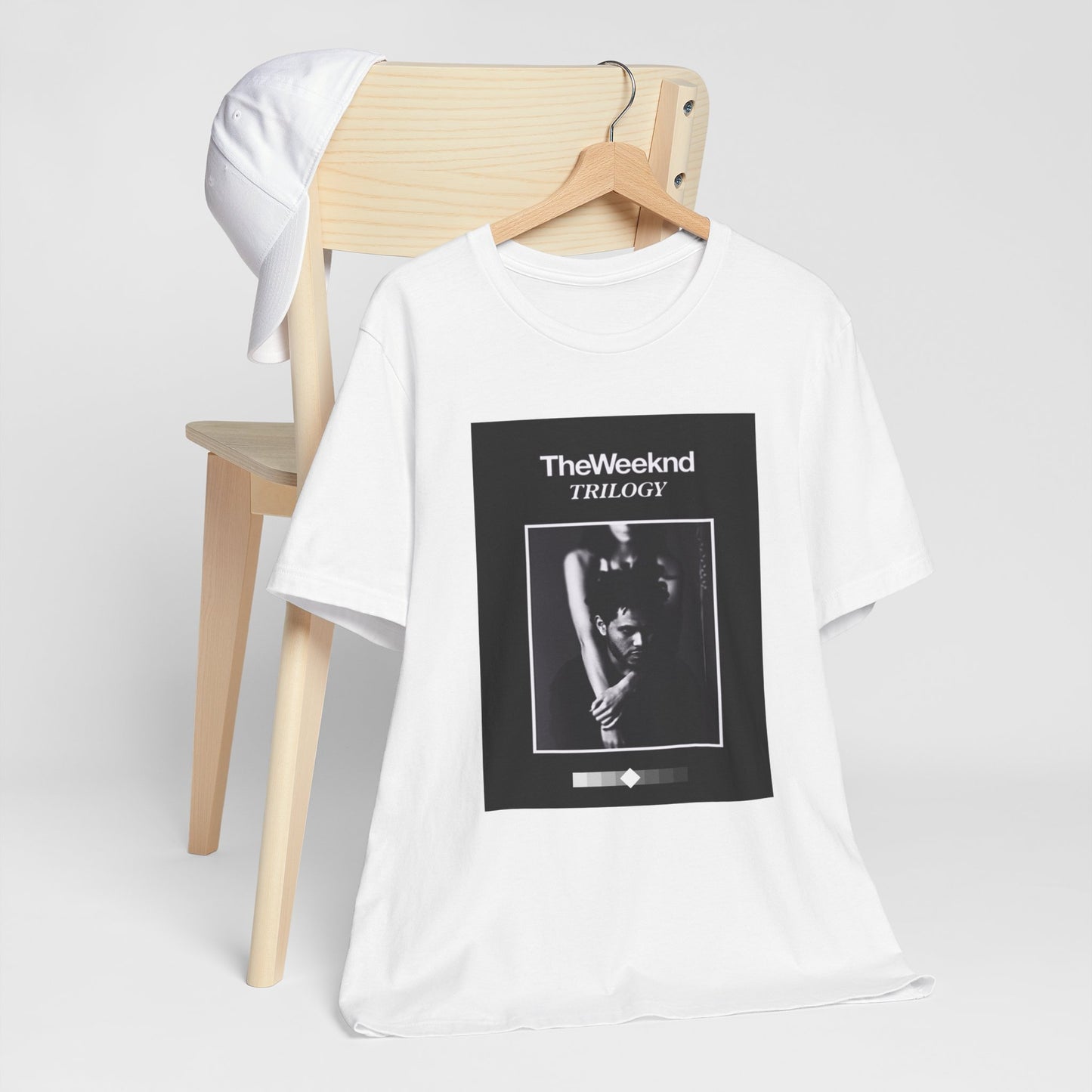 A black graphic t-shirt featuring a graphic related to The Weeknd's 'Trilogy' album.