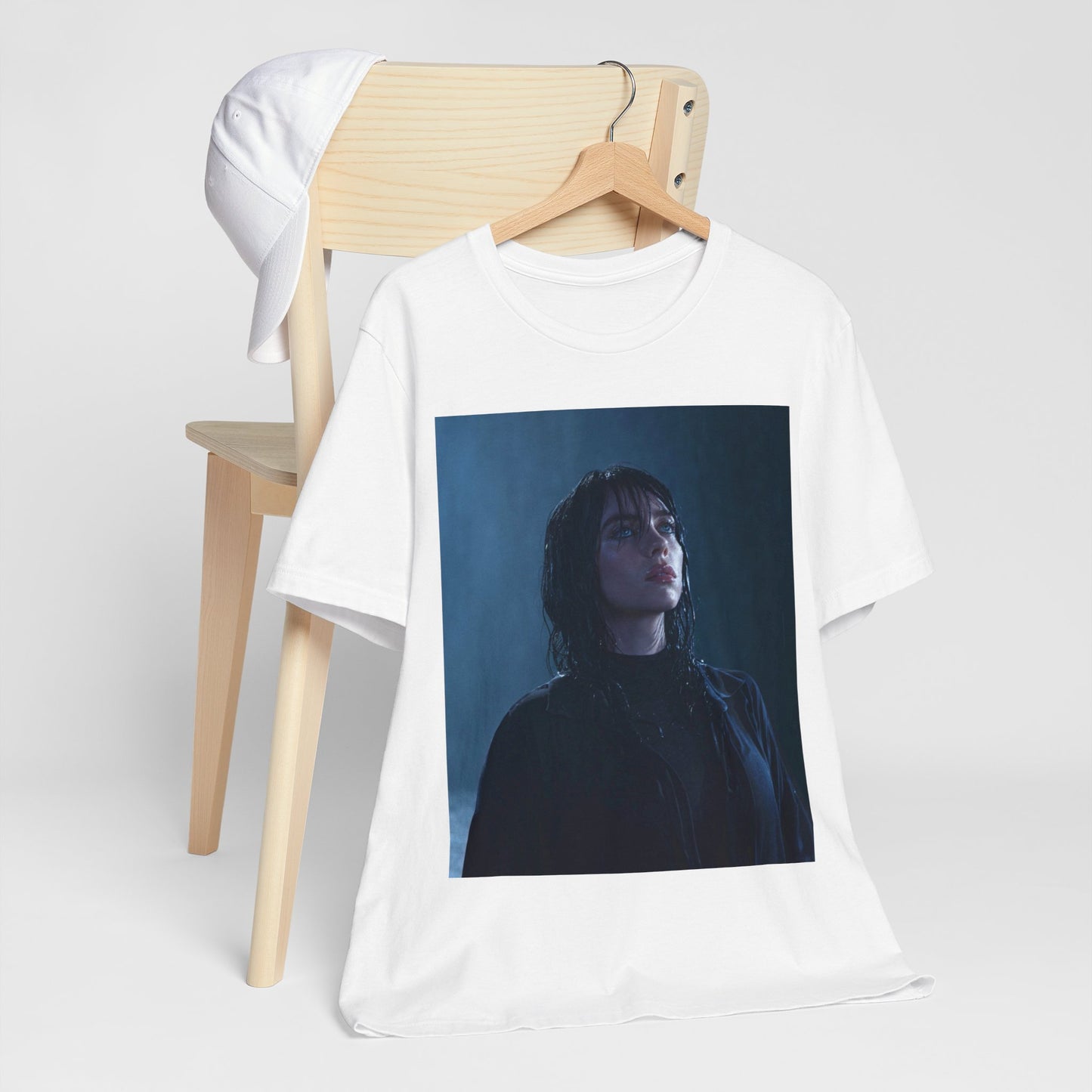 A direct, powerful portrait of Billie Eilish, embodying the 'HIT ME HARD AND SOFT' album era, printed on a graphic t-shirt.
