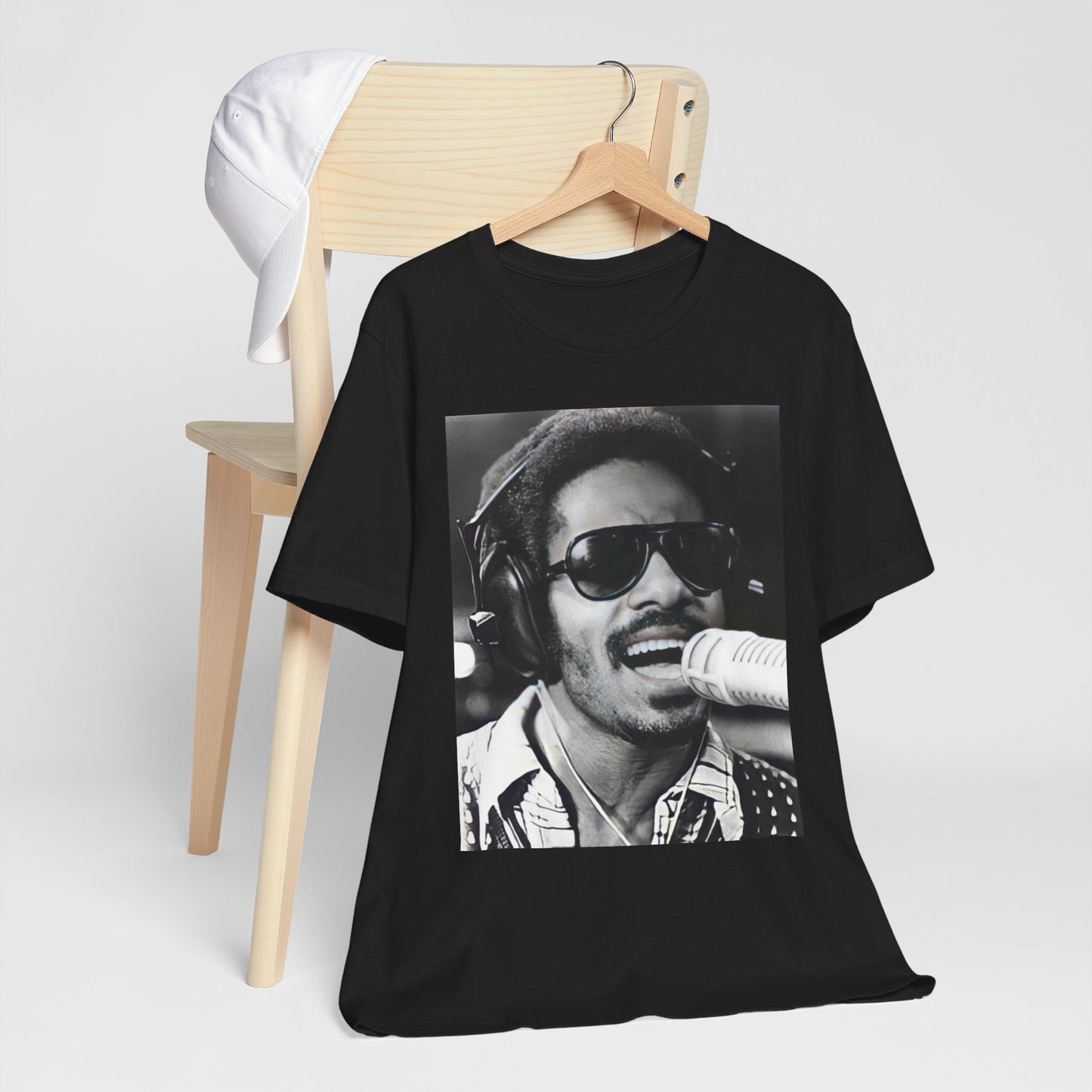 A black graphic t-shirt featuring a graphic of Stevie Wonder as a timeless visionary.