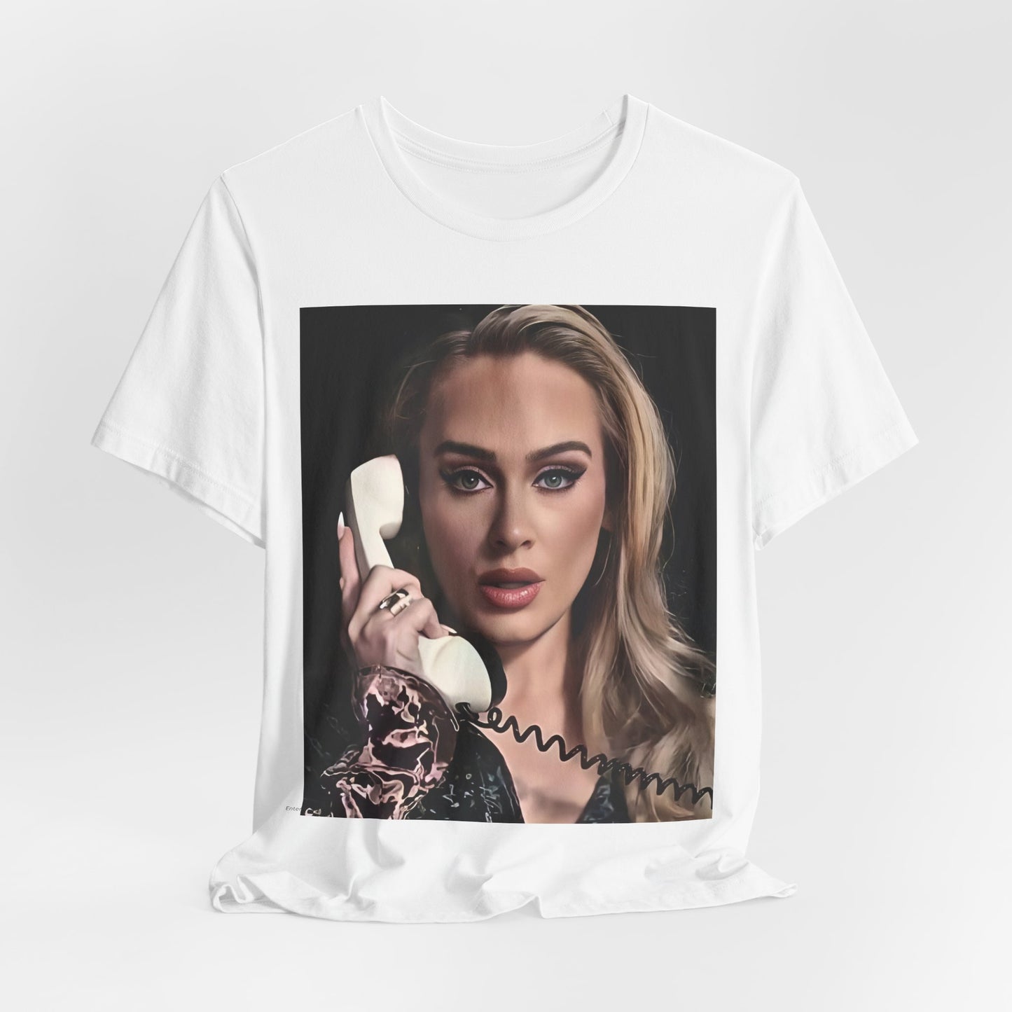 A black graphic t-shirt featuring a black and white candid photo of Adele with a phone to her ear, showing a thoughtful or emotional expression.