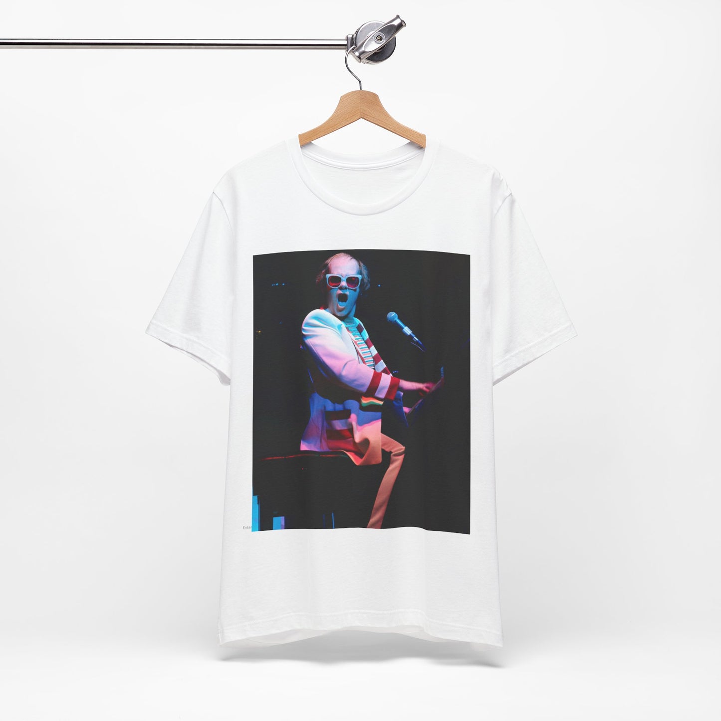 A black graphic t-shirt featuring a photo of Elton John performing live on stage at his piano.