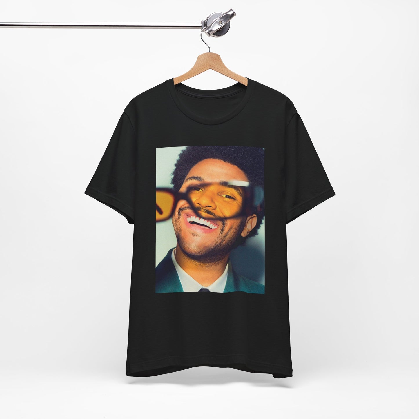 A black graphic t-shirt featuring a bold graphic of The Weeknd as a pop superstar.