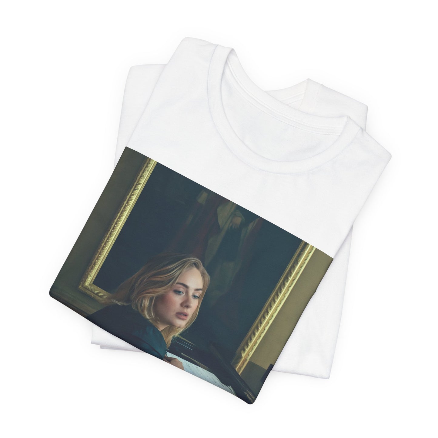 A black graphic t-shirt featuring a black and white photo of Adele sitting at a piano, with a focused and emotional expression as if performing.