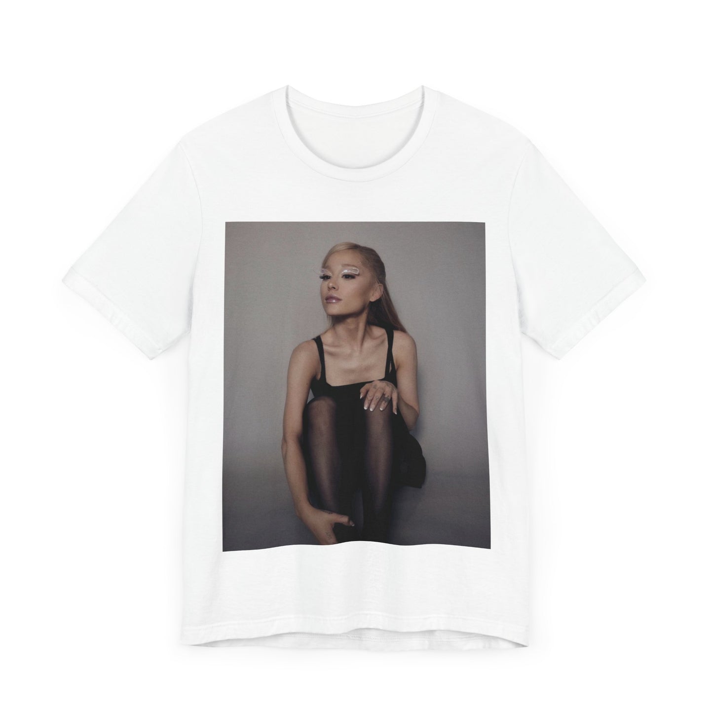 A black graphic t-shirt featuring a bold and beautiful graphic of Ariana Grande, emphasizing her strong and confident presence.