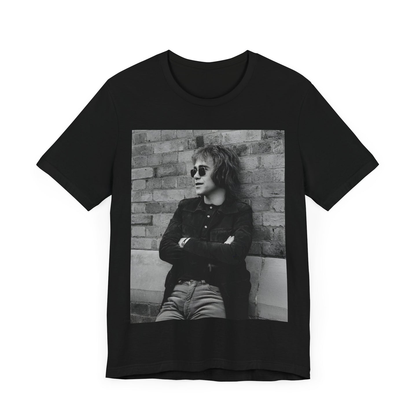 A black graphic t-shirt featuring a vintage graphic related to Elton John's 'Farewell Yellow Brick Road' tour.