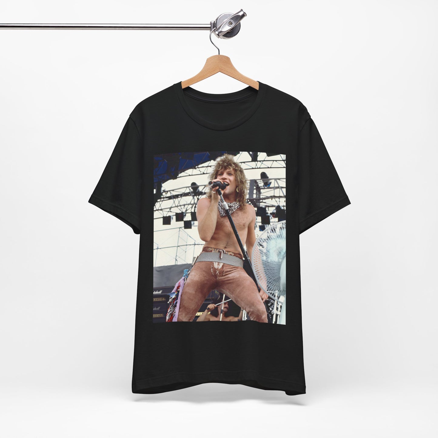A black graphic t-shirt featuring a dynamic graphic or photo of Bon Jovi performing live on stage with a fierce intensity.