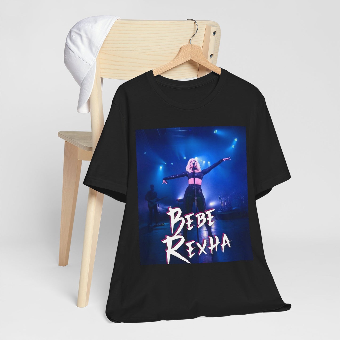A black graphic t-shirt featuring a dynamic graphic or photo of Bebe Rexha performing live on stage.