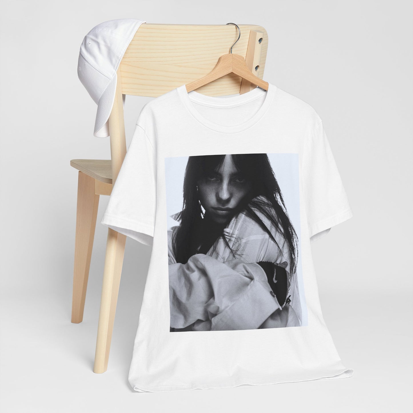 Billie Eilish posing in her signature oversized designer streetwear, printed on a graphic t-shirt.