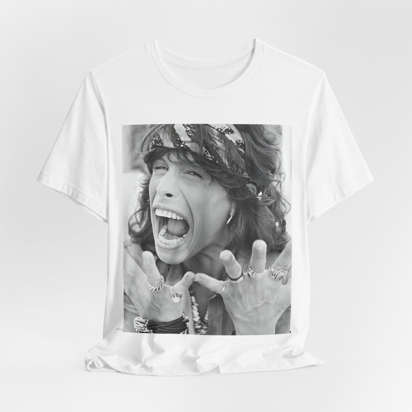 A black graphic t-shirt featuring a candid, dynamic photo of Aerosmith band members on tour in the 1970s, possibly showing action or interaction on stage or backstage.