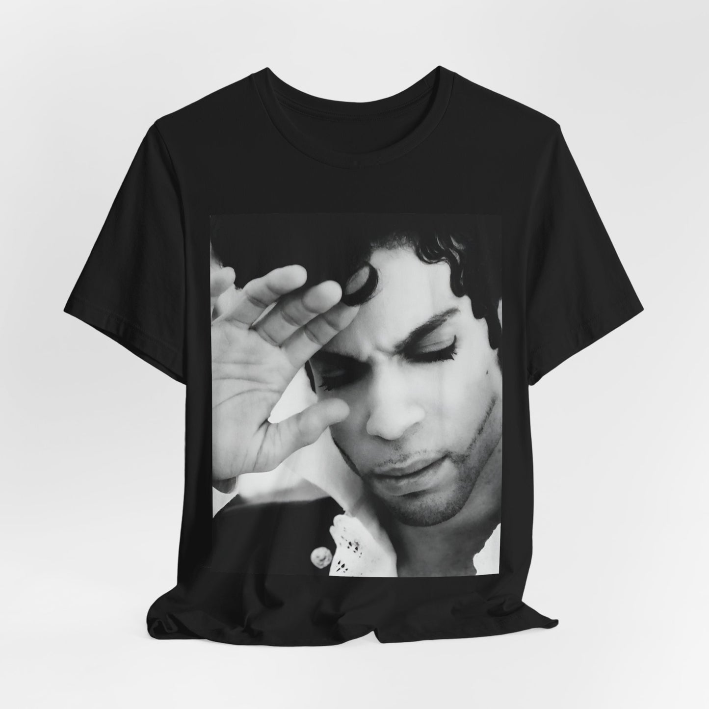 A black graphic t-shirt featuring a black and white graphic or photo portrait of Prince.