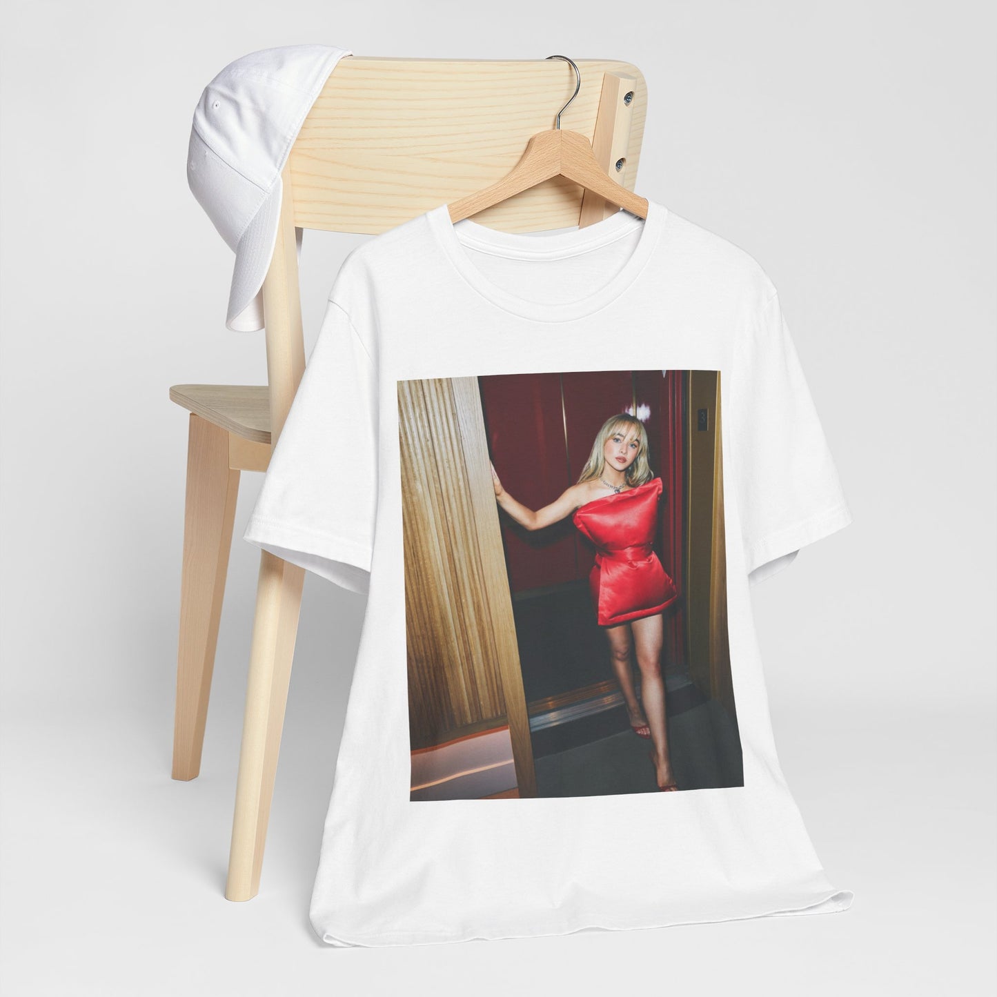 A black graphic t-shirt featuring a graphic of Sabrina Carpenter with 'hot pop vibes'.