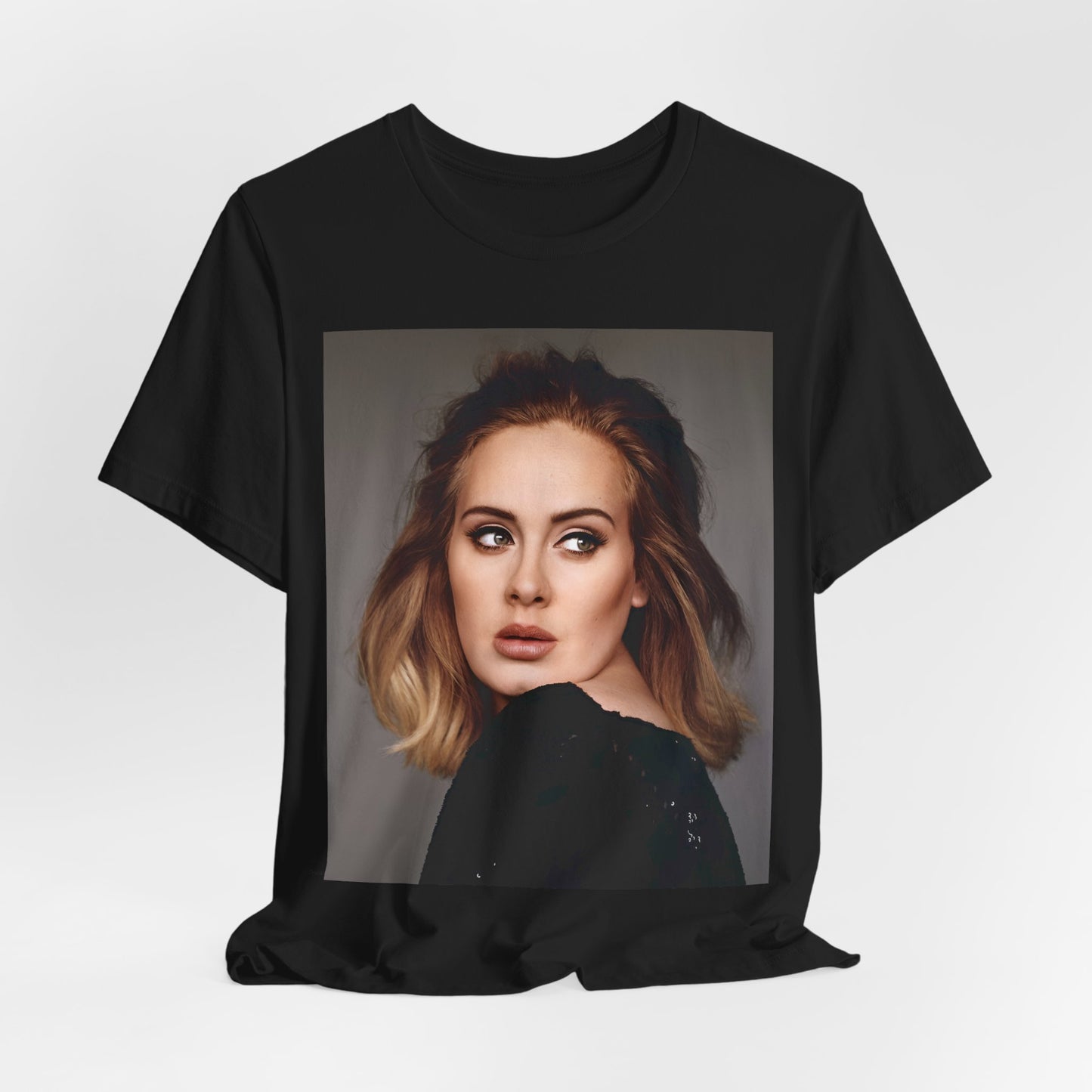 A black graphic t-shirt featuring a studio portrait of Adele from her '25' album era, showing a thoughtful or serene expression.