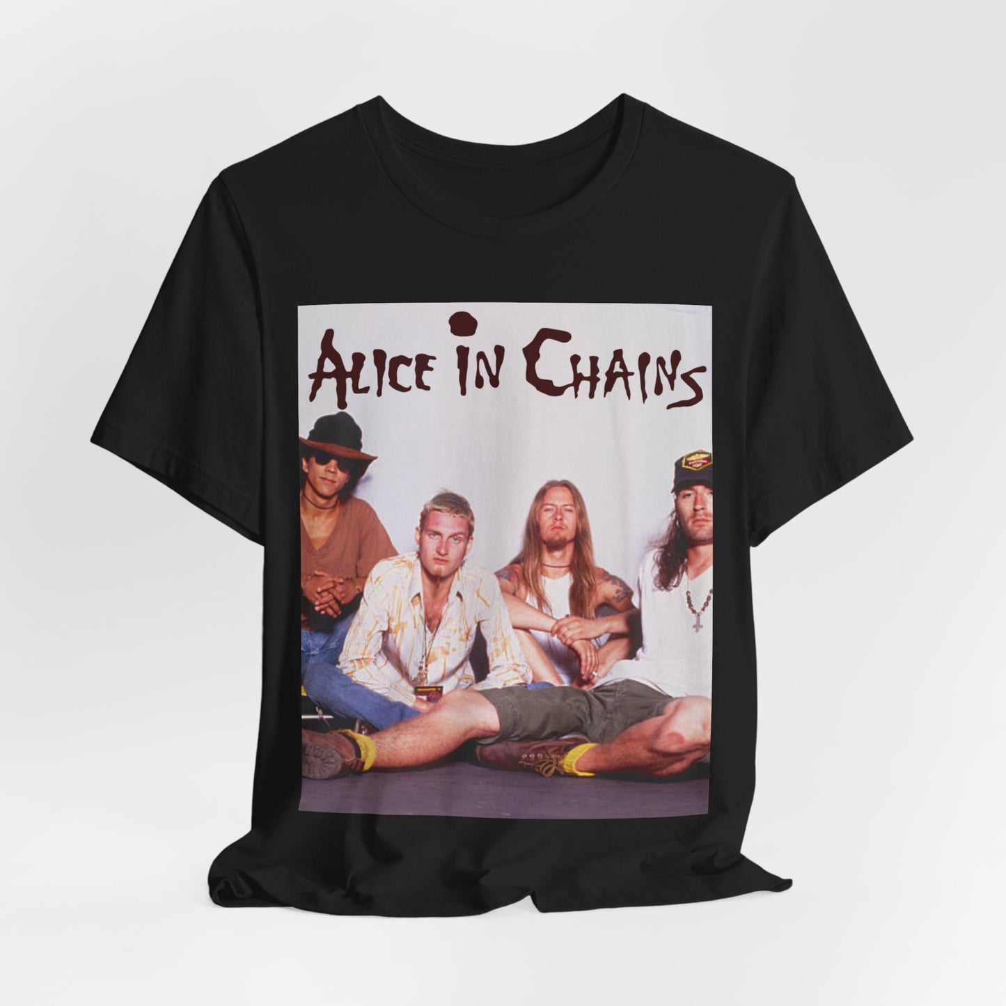 A black graphic t-shirt featuring a classic rock graphic of Alice In Chains from the 1990s, possibly with band members or stylized logo.