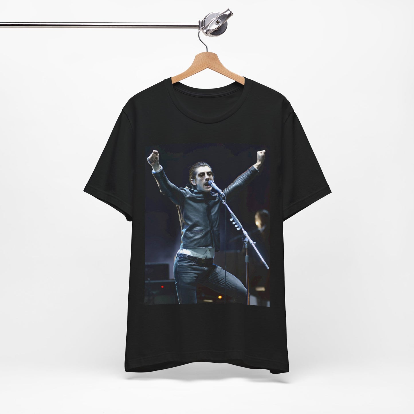 A black graphic t-shirt featuring a graphic or photo of Arctic Monkeys performing live on stage, with a Britpop aesthetic.