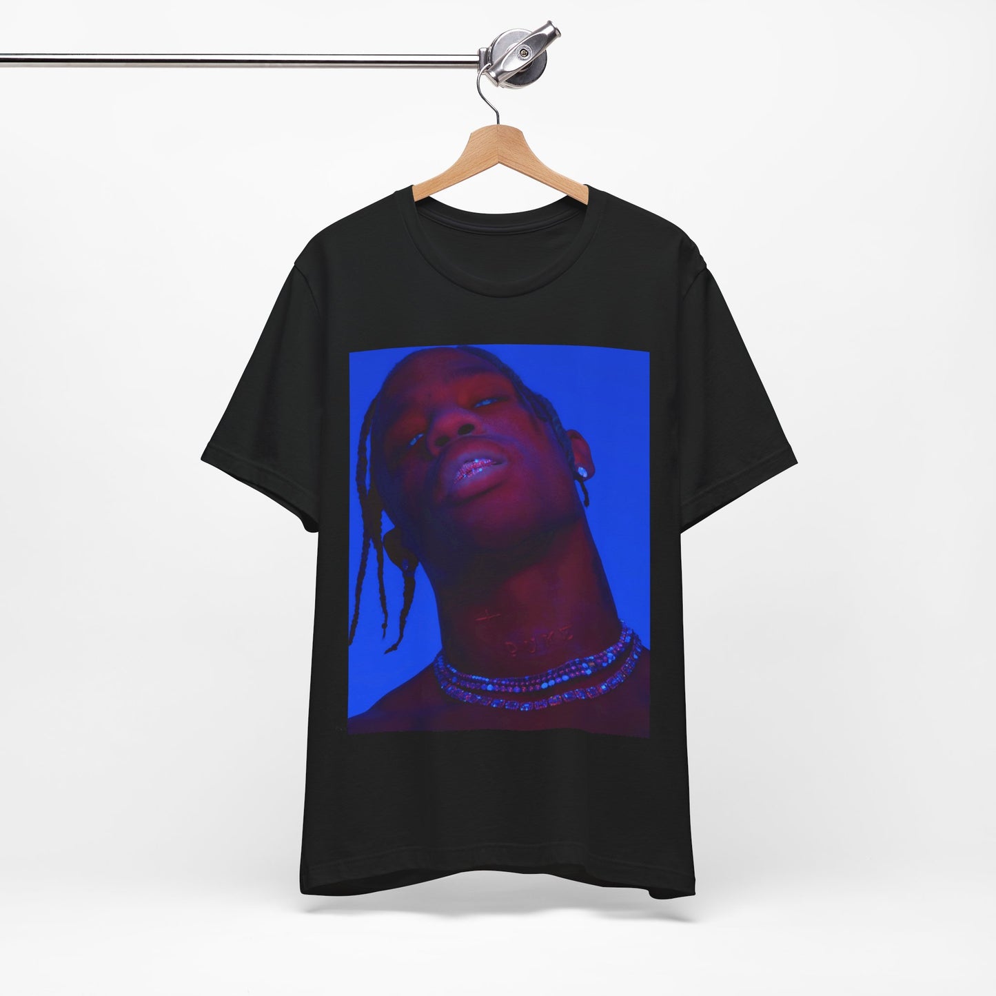 A black graphic t-shirt featuring a bold graphic of Travis Scott as a rap superstar.