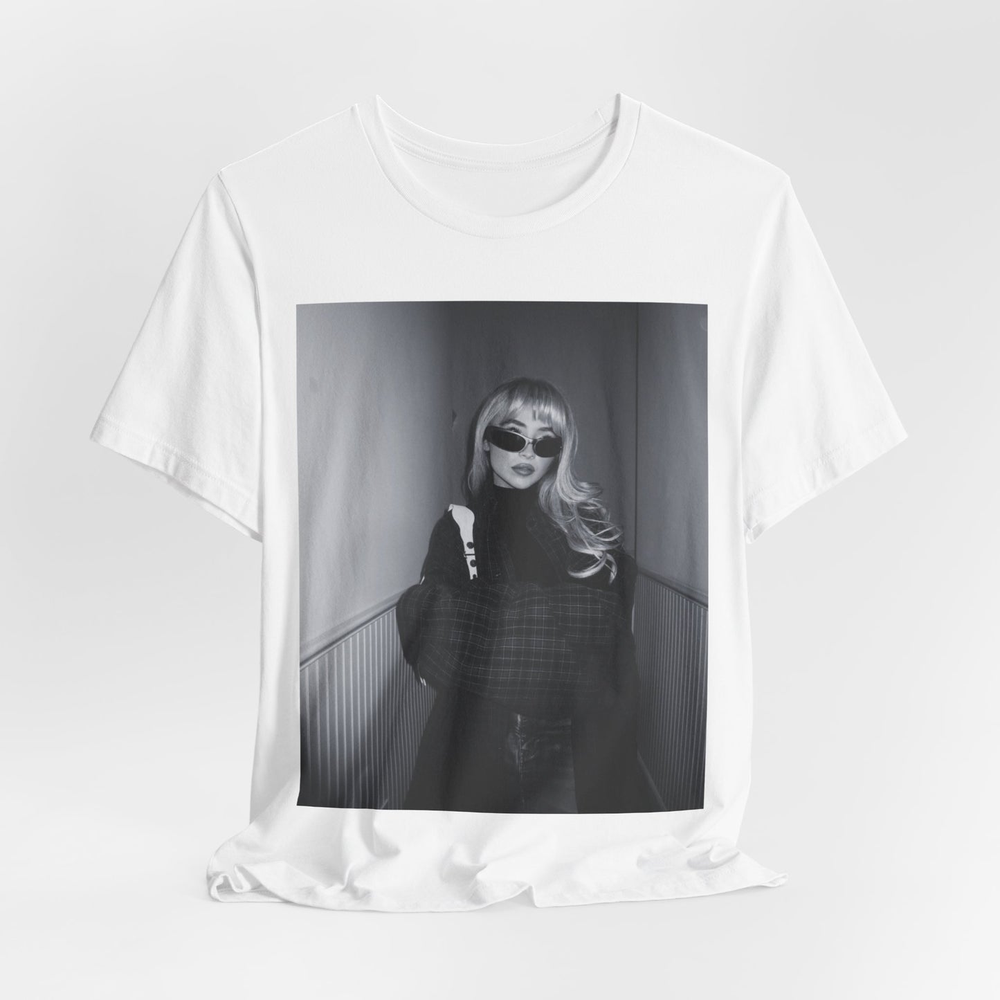 A black graphic t-shirt featuring a black and white glam pop diva graphic of Sabrina Carpenter.