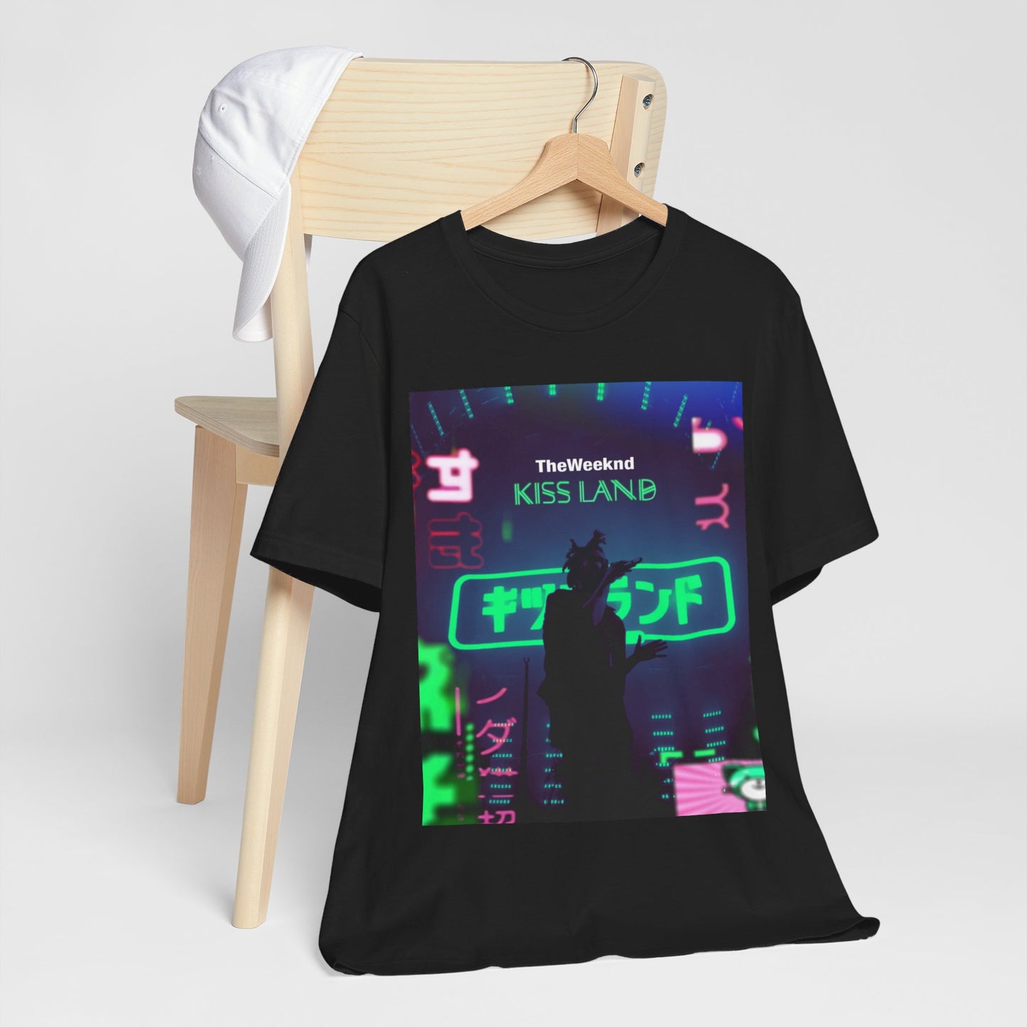 A black graphic t-shirt featuring a graphic related to The Weeknd's 'Kiss Land' live performances.