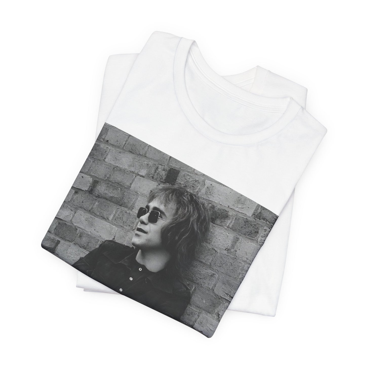 A black graphic t-shirt featuring a vintage graphic related to Elton John's 'Farewell Yellow Brick Road' tour.