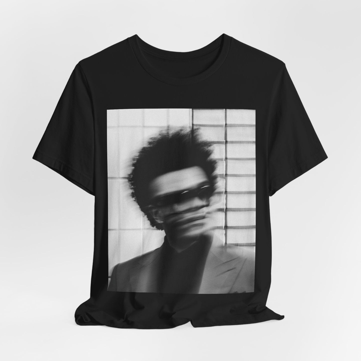 A black graphic t-shirt featuring a blurred graphic of The Weeknd from his 'After Hours' era.