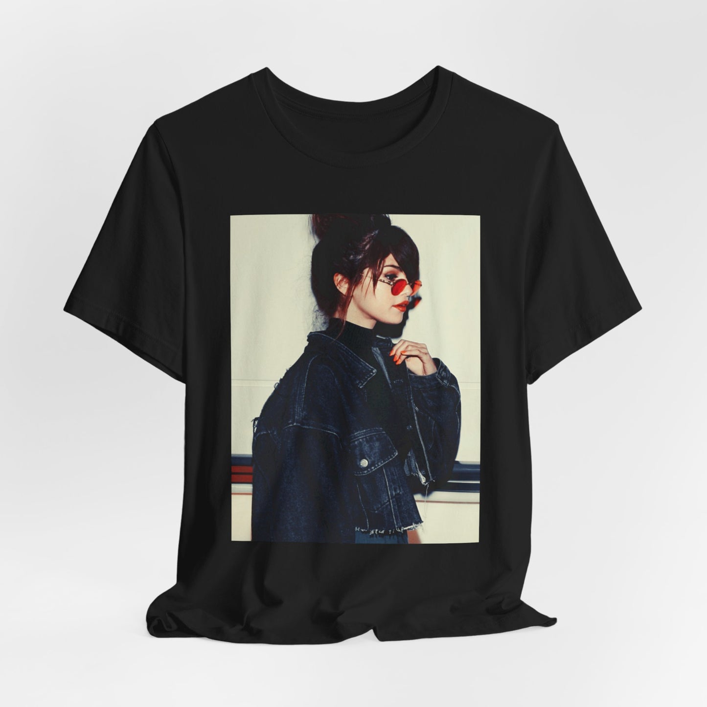 A black graphic t-shirt featuring a bold graphic of Selena Gomez as a pop superstar.