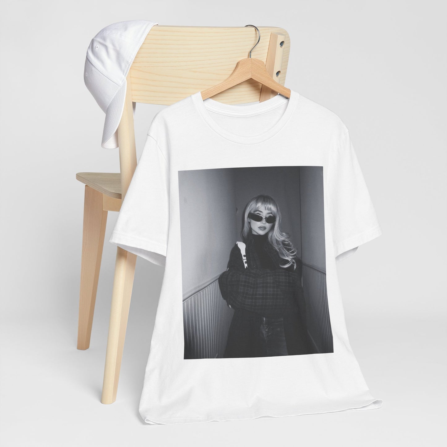 A black graphic t-shirt featuring a black and white glam pop diva graphic of Sabrina Carpenter.