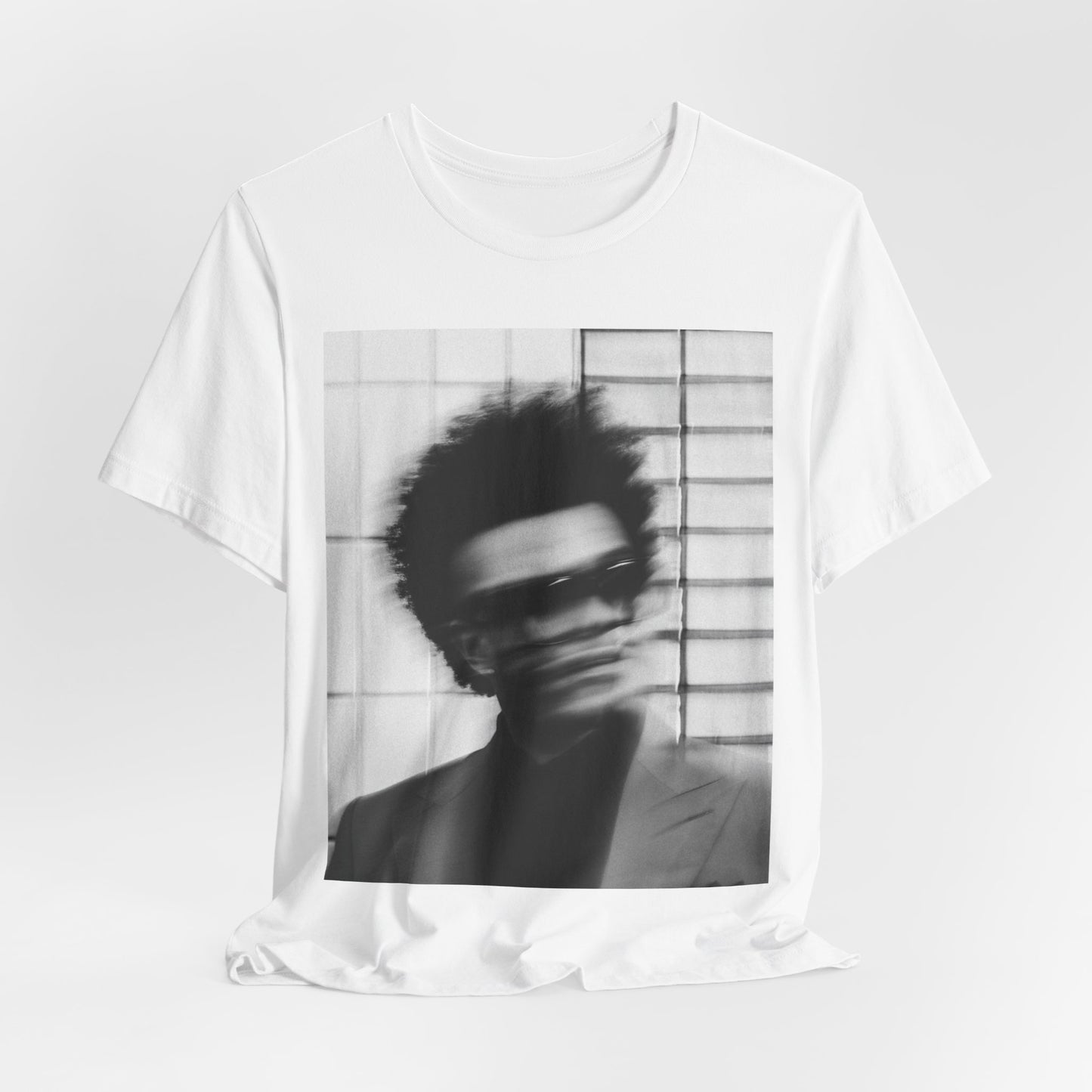 A black graphic t-shirt featuring a blurred graphic of The Weeknd from his 'After Hours' era.