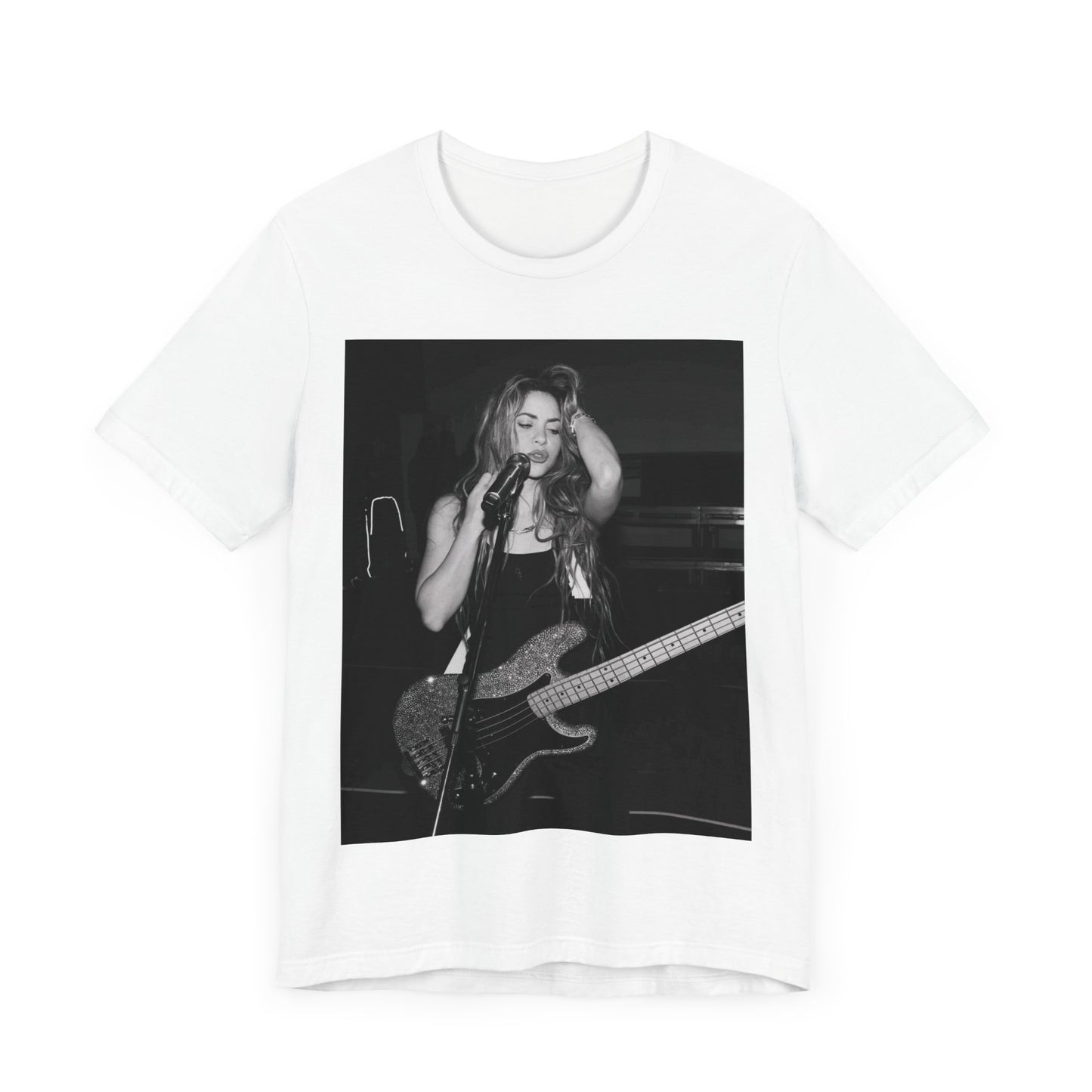 A black graphic t-shirt featuring a black and white graphic or photo of Shakira playing guitar live.