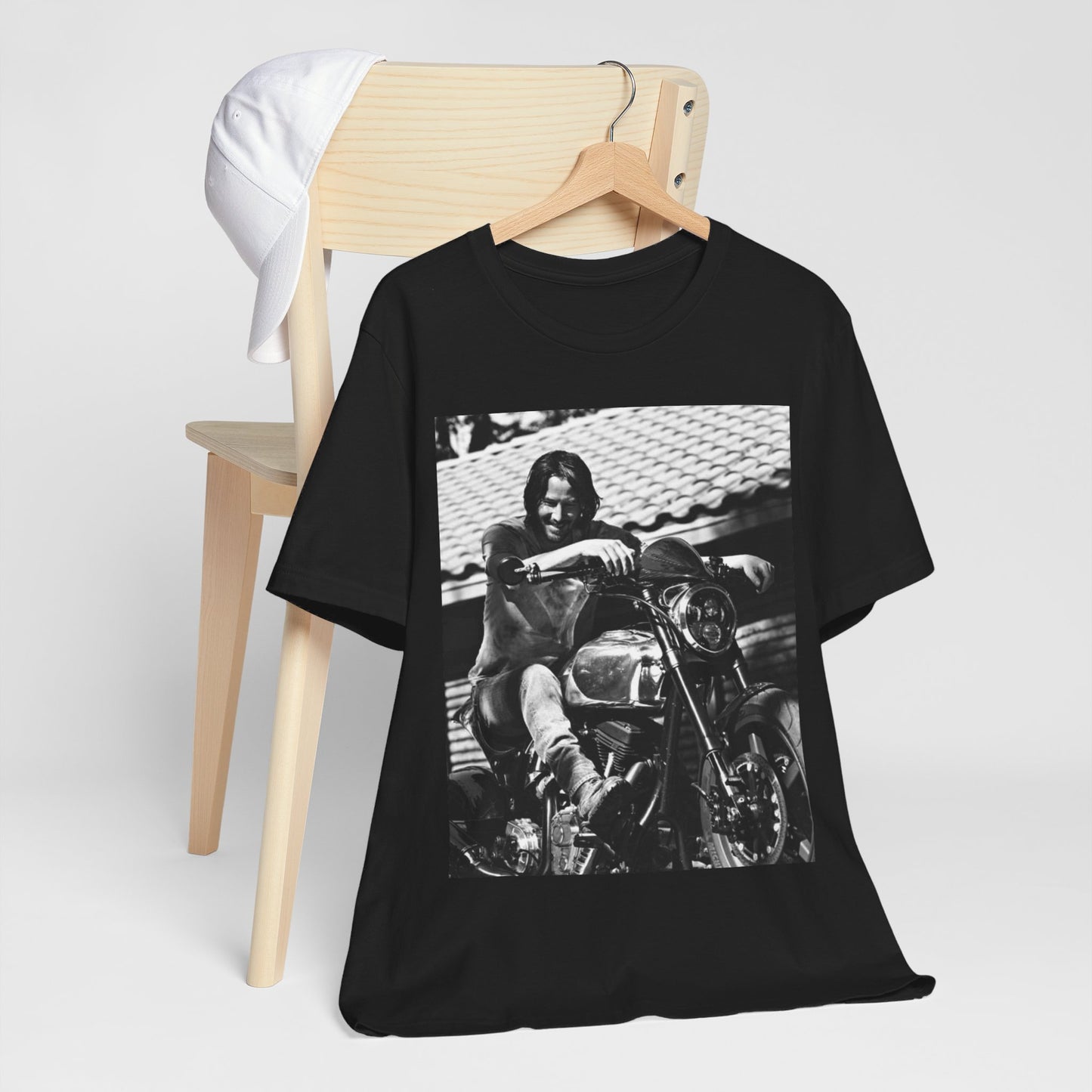 A black graphic t-shirt featuring a black and white photo of Keanu Reeves on a motorcycle.