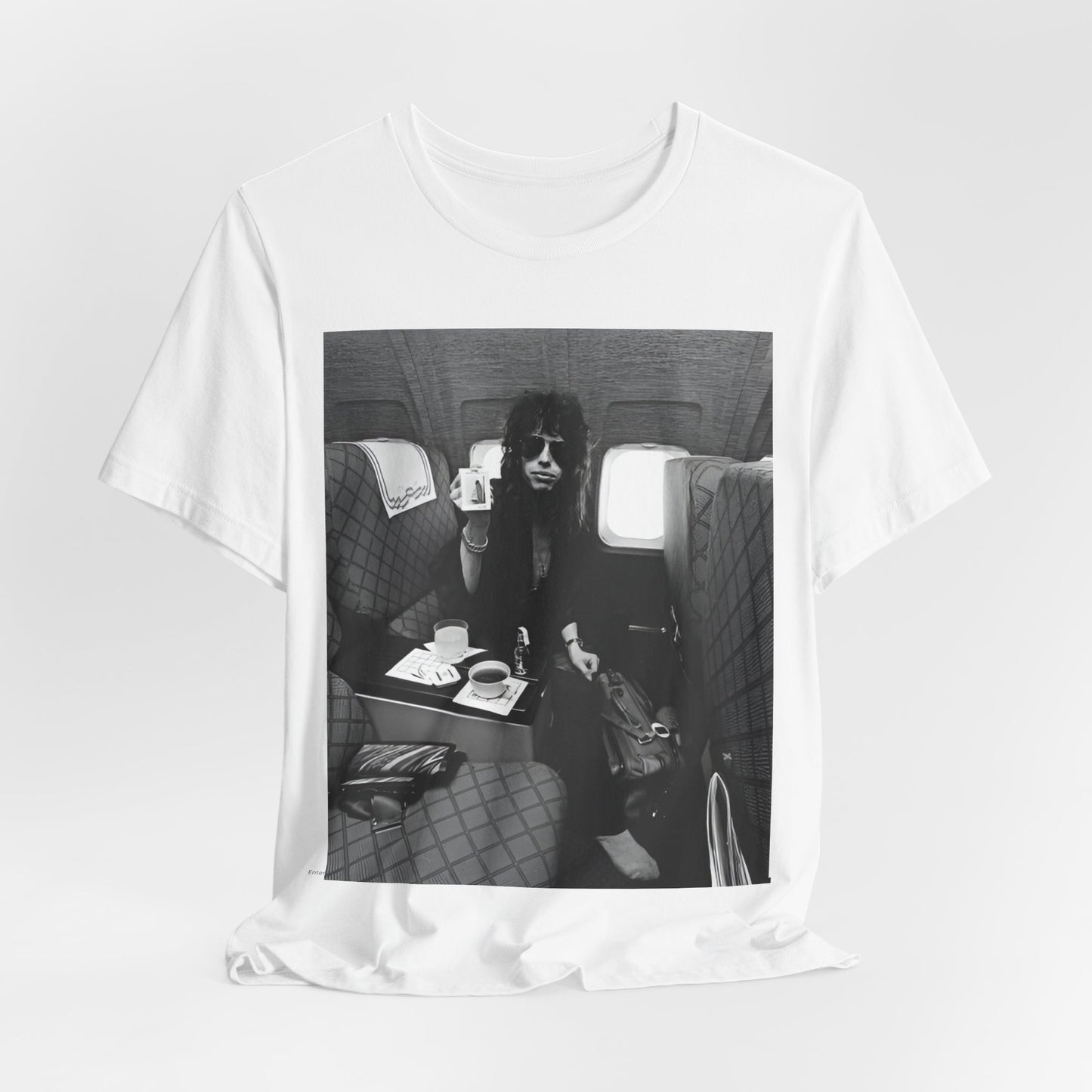 A black graphic t-shirt featuring a vintage 70s-style illustration of an airplane with Aerosmith branding, representing their tour plane from that era.