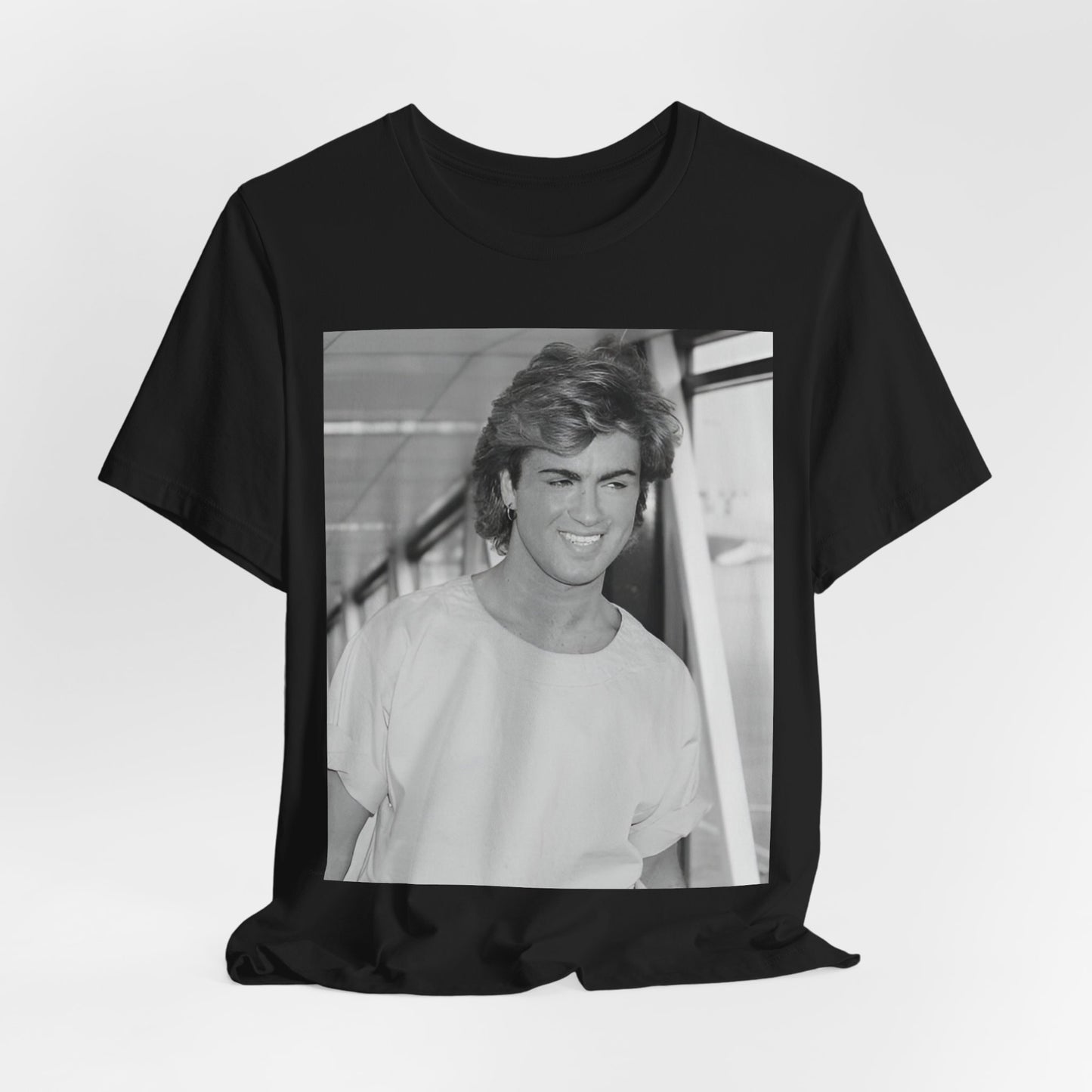 A black graphic t-shirt featuring an 80s black and white vintage photo or graphic of George Michael.