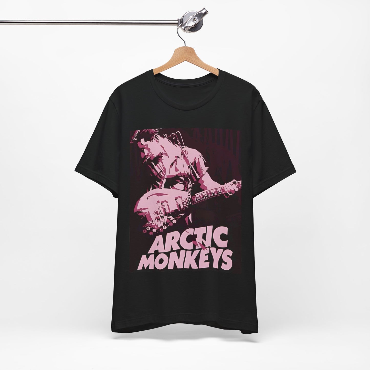 A black graphic t-shirt featuring the Arctic Monkeys logo in a prominent pink color, creating an aesthetic look.
