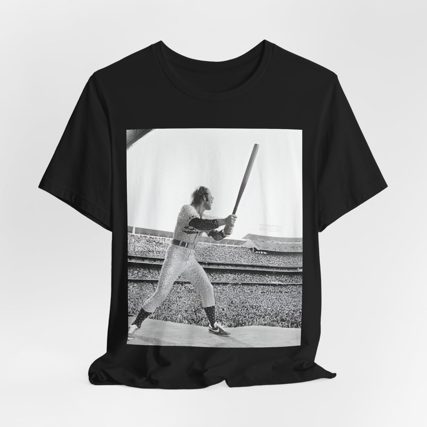 A black graphic t-shirt featuring a black and white graphic or photo related to Elton John's 1975 tour in America.