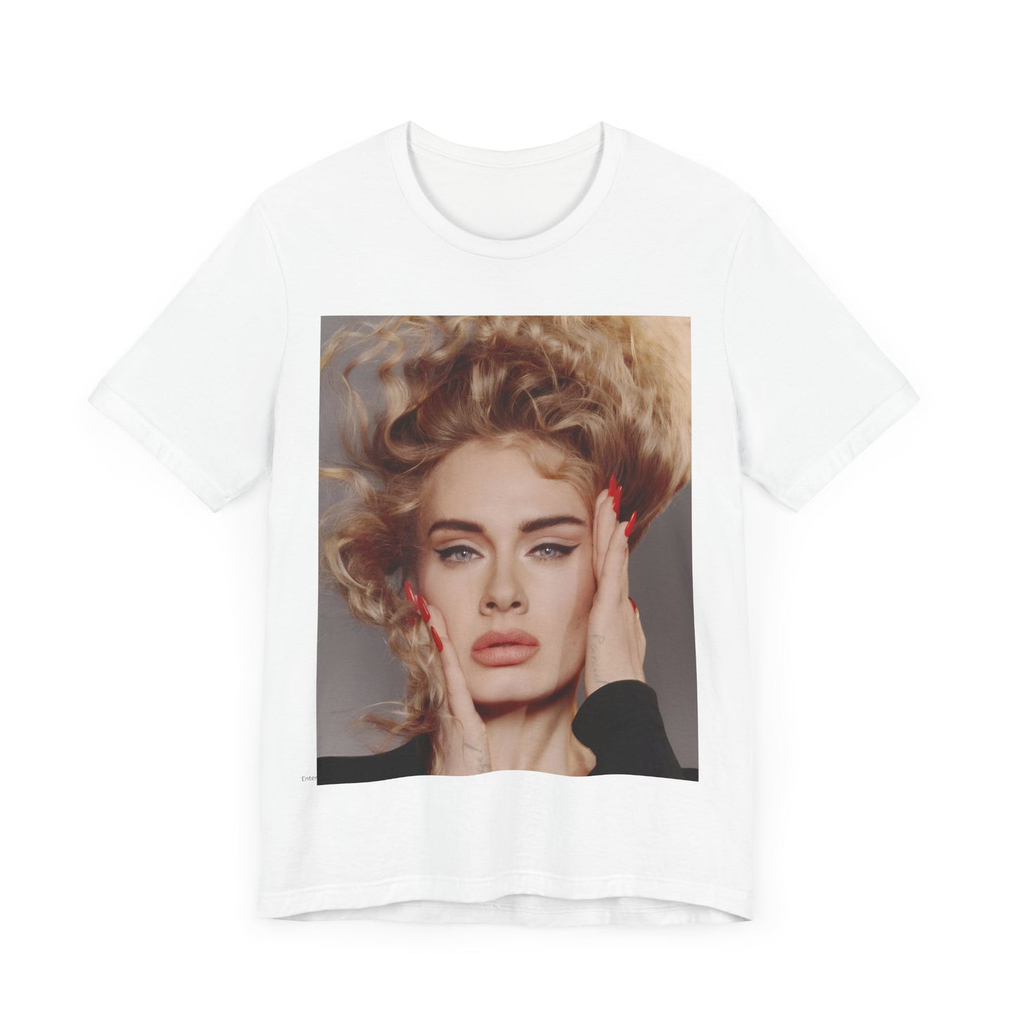A black graphic t-shirt featuring a detailed, artistic black and white portrait of Adele with her hair dramatically caught in a breeze around her face and her hands gently placed on her cheeks.