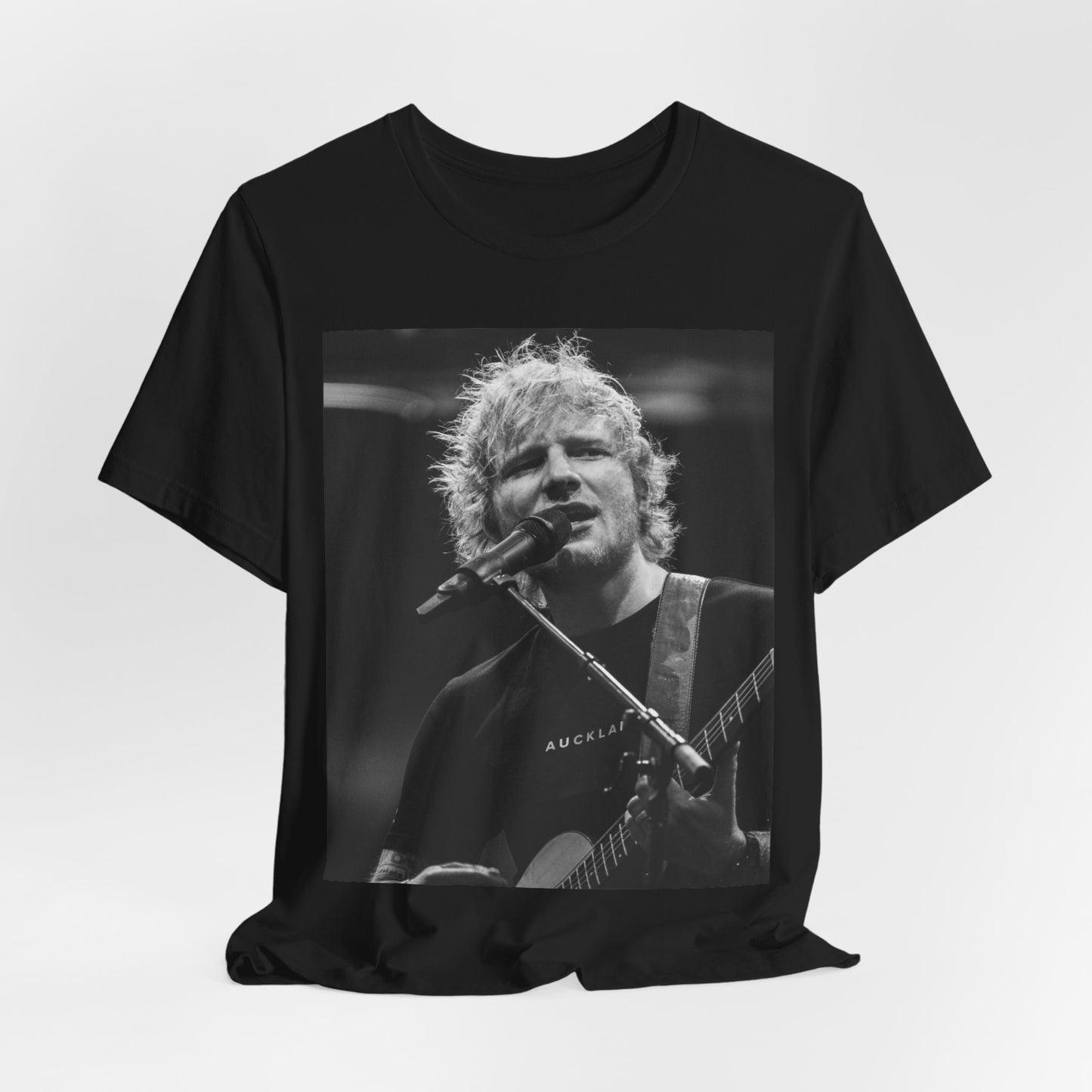 A black graphic t-shirt featuring a black and white photo of Ed Sheeran performing live.