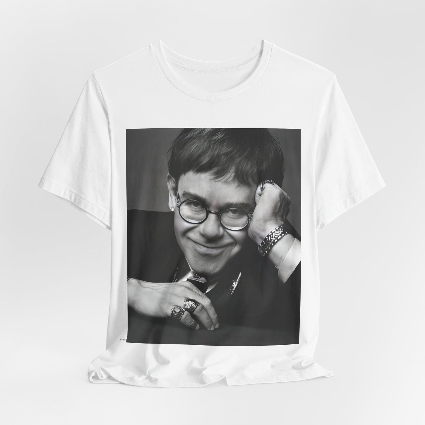 A black graphic t-shirt featuring a retro black and white photo portrait of Elton John.