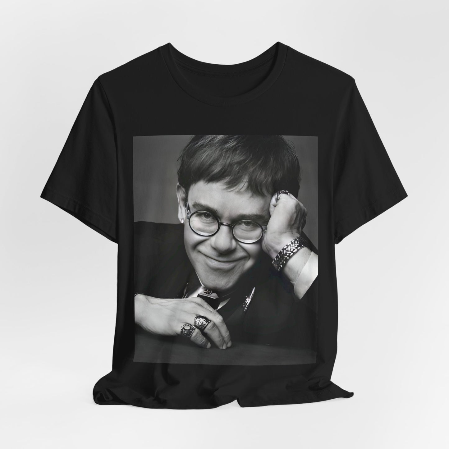 A black graphic t-shirt featuring a retro black and white photo portrait of Elton John.