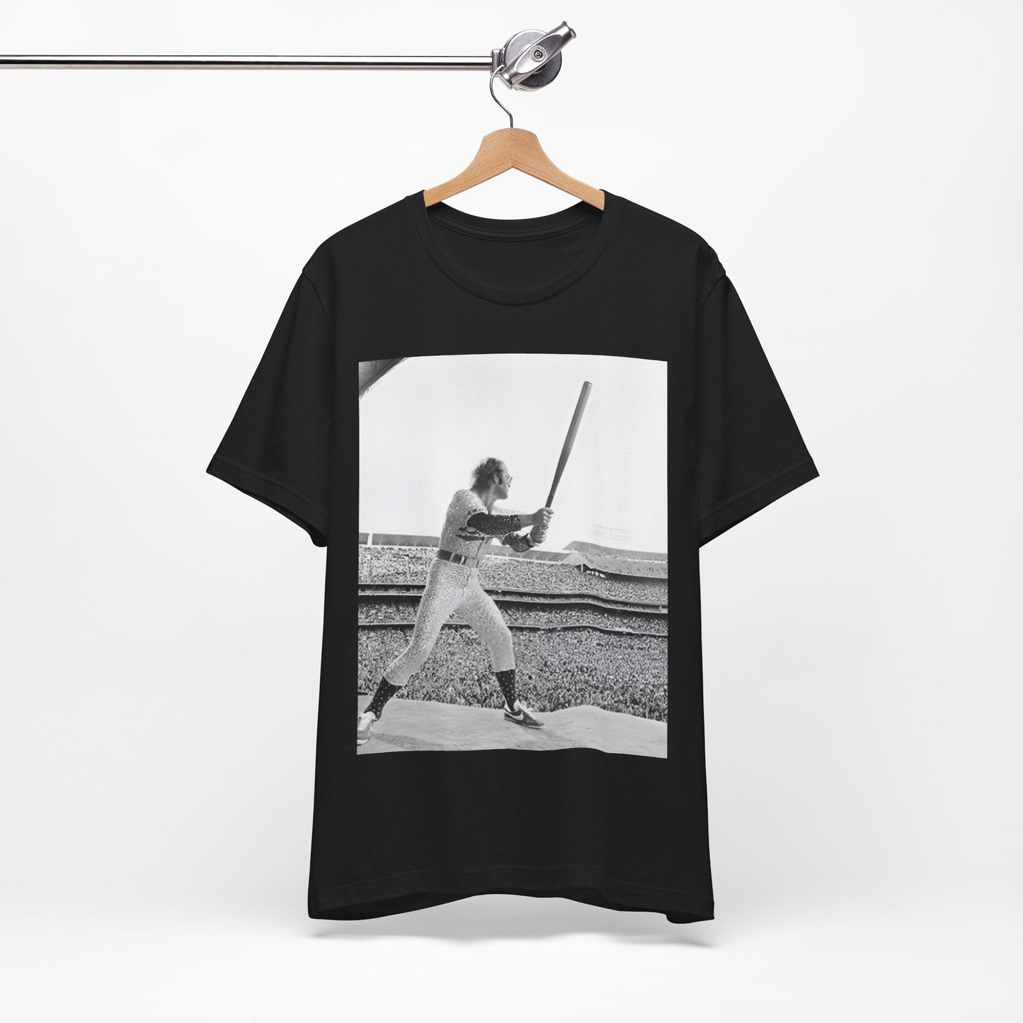 A black graphic t-shirt featuring a black and white graphic or photo related to Elton John's 1975 tour in America.