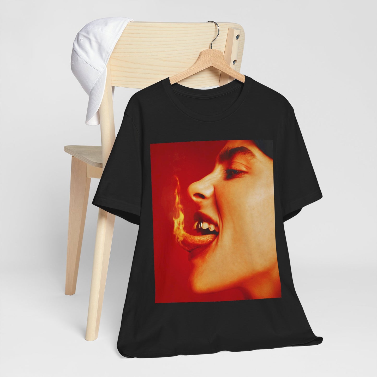 A close-up, red-toned photo of a face in profile with its mouth open and a live flame on the tongue, printed on a graphic t-shirt.