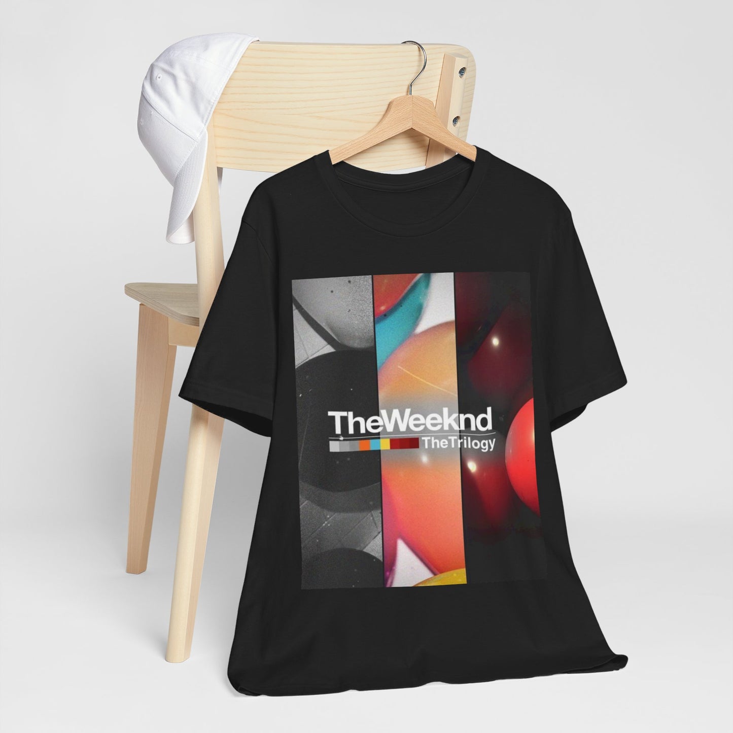 A black graphic t-shirt featuring a graphic related to The Weeknd's 'The Trilogy' album.