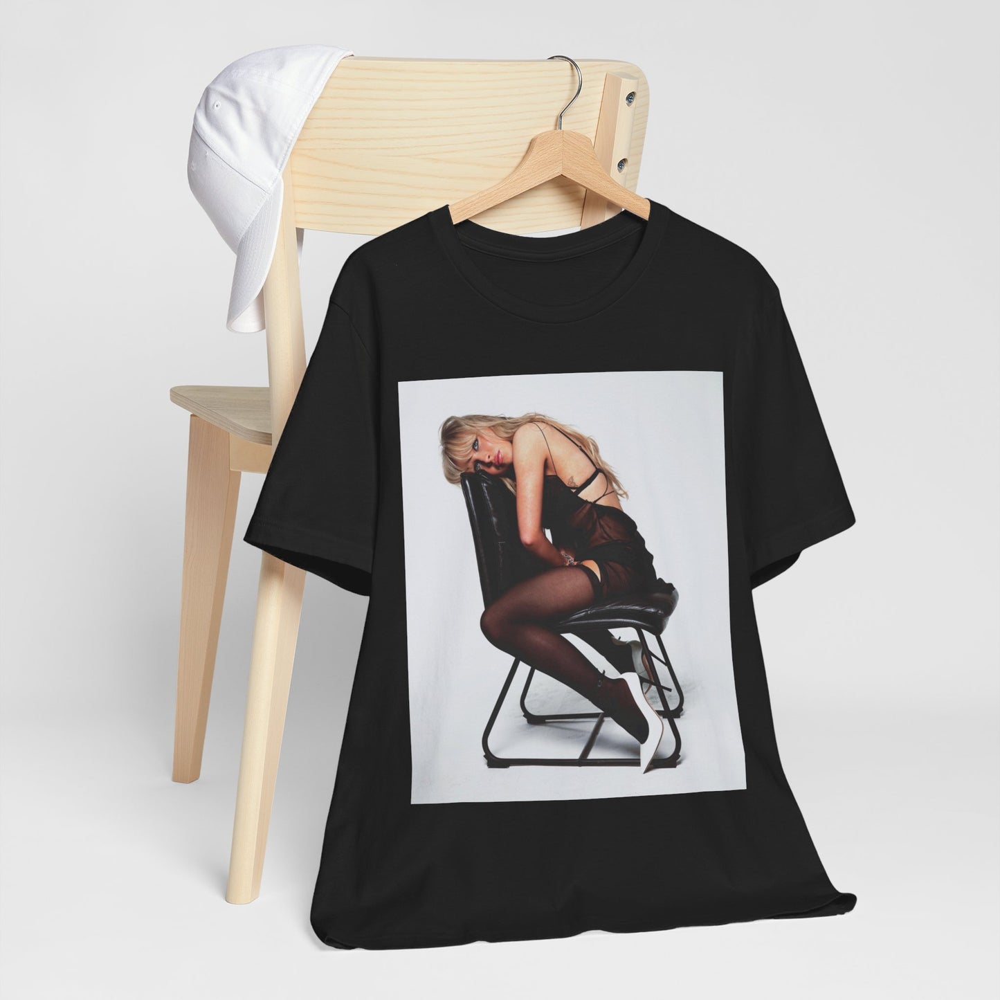 A black graphic t-shirt featuring a playful pop art style graphic of Sabrina Carpenter.