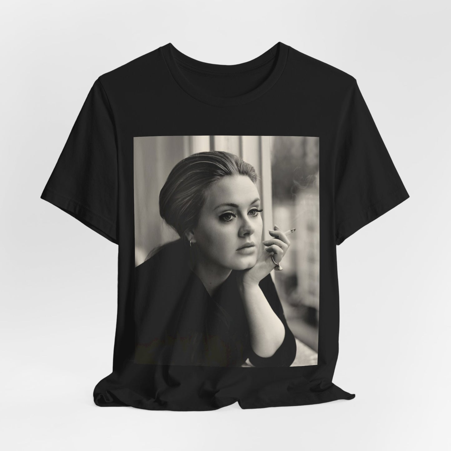 A black graphic t-shirt featuring a black and white photo of Adele, showing her with a serene or thoughtful expression.