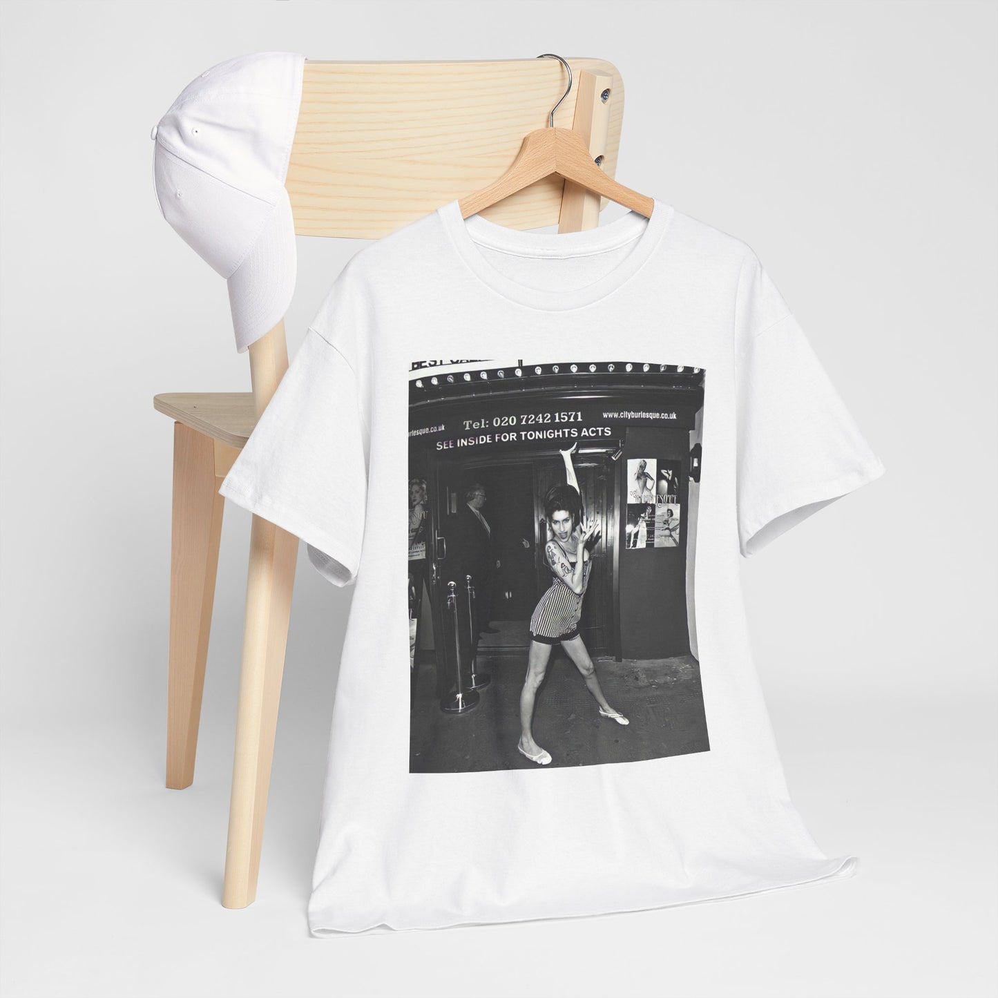 A black graphic t-shirt featuring a black and white graphic of Amy Winehouse in a burlesque club setting, stylized to evoke that ambiance.