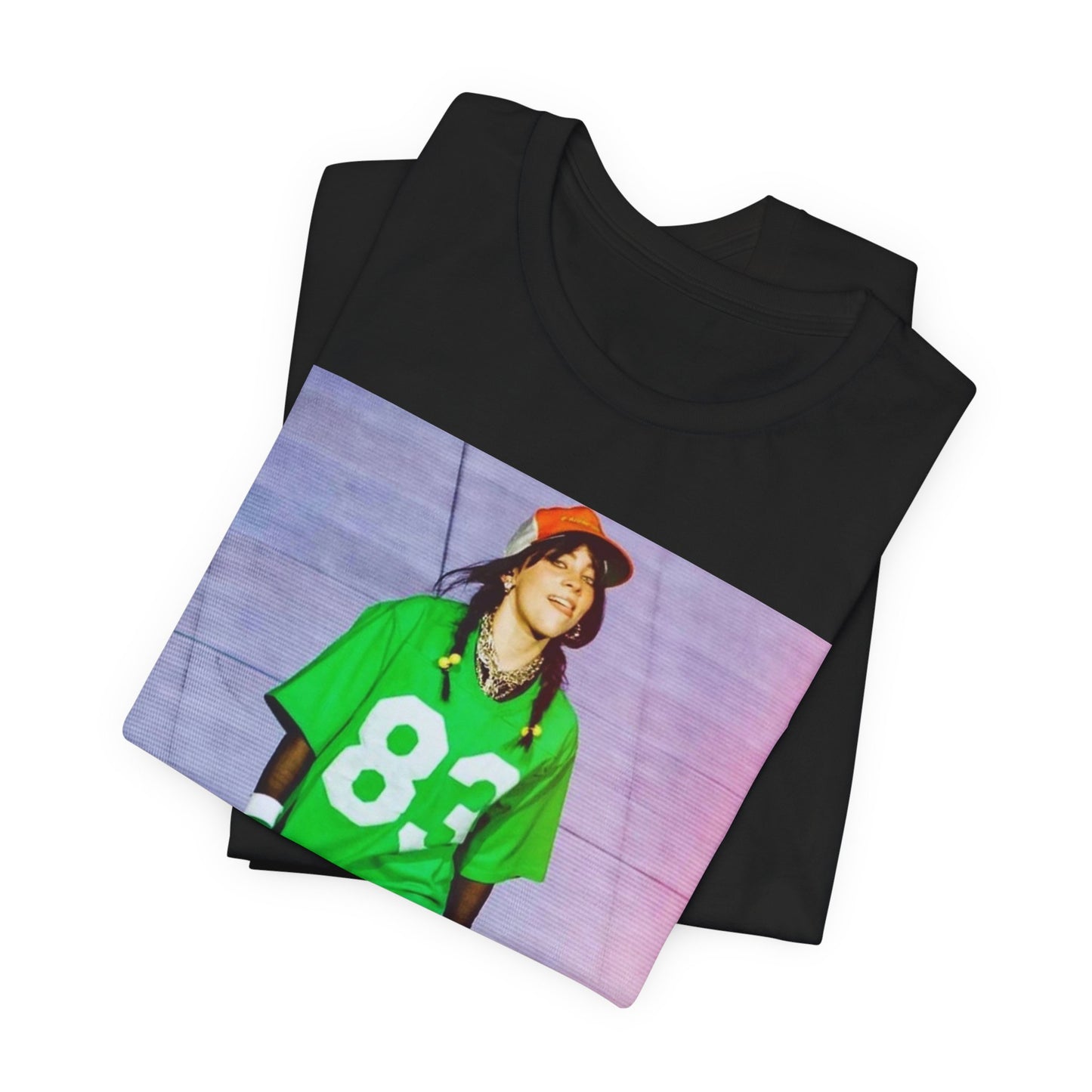 Billie Eilish performing on stage wearing a large green basketball jersey with the number 83 and an orange backwards cap.