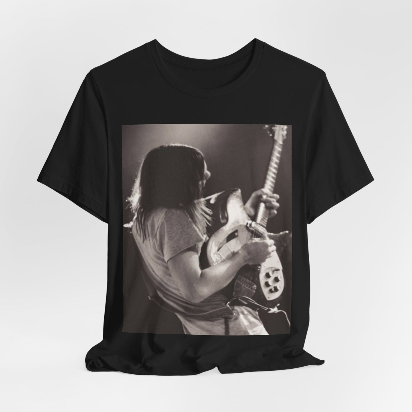 A black graphic t-shirt featuring a black and white graphic or photo of Tame Impala performing live on stage.