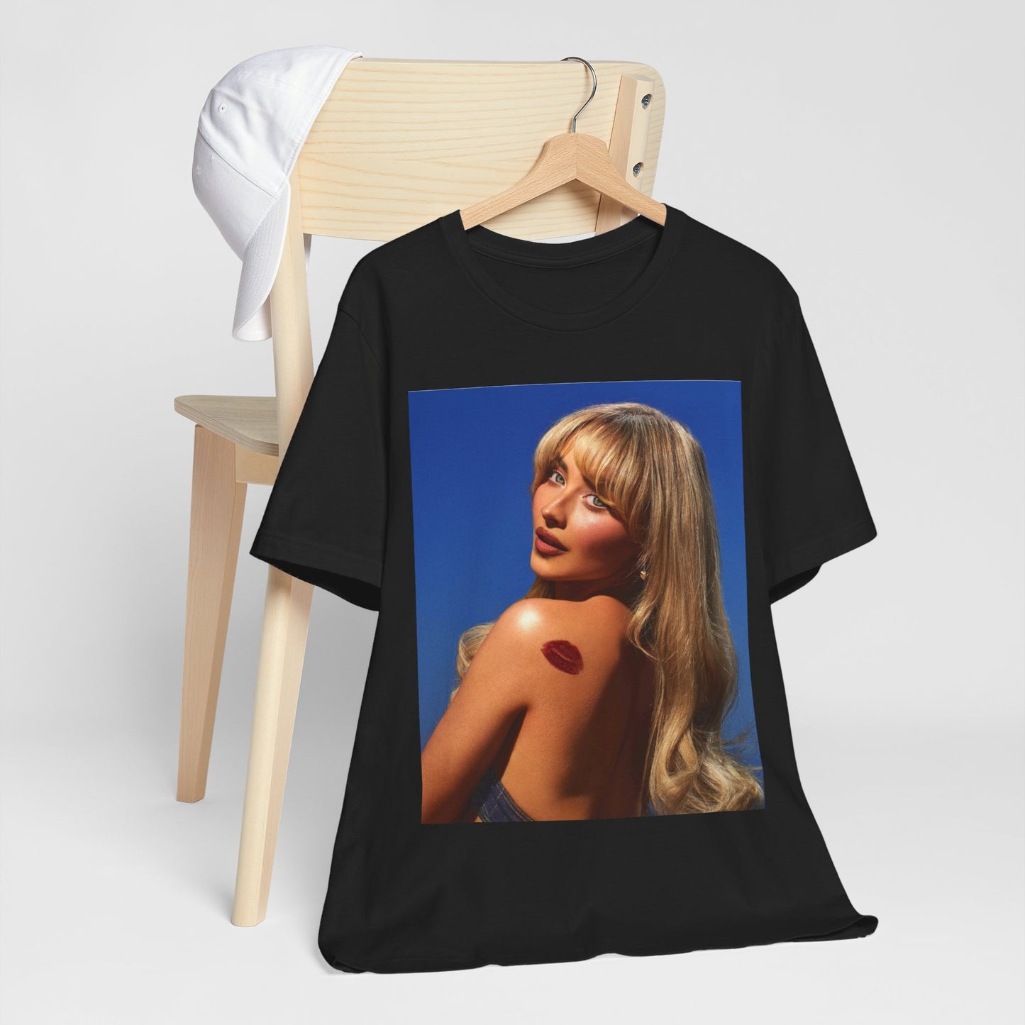 A black graphic t-shirt featuring a stylized graphic of Sabrina Carpenter, designed with a modern pop aesthetic.