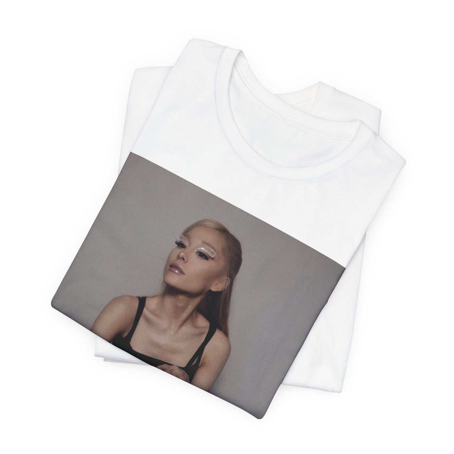 A black graphic t-shirt featuring a bold and beautiful graphic of Ariana Grande, emphasizing her strong and confident presence.