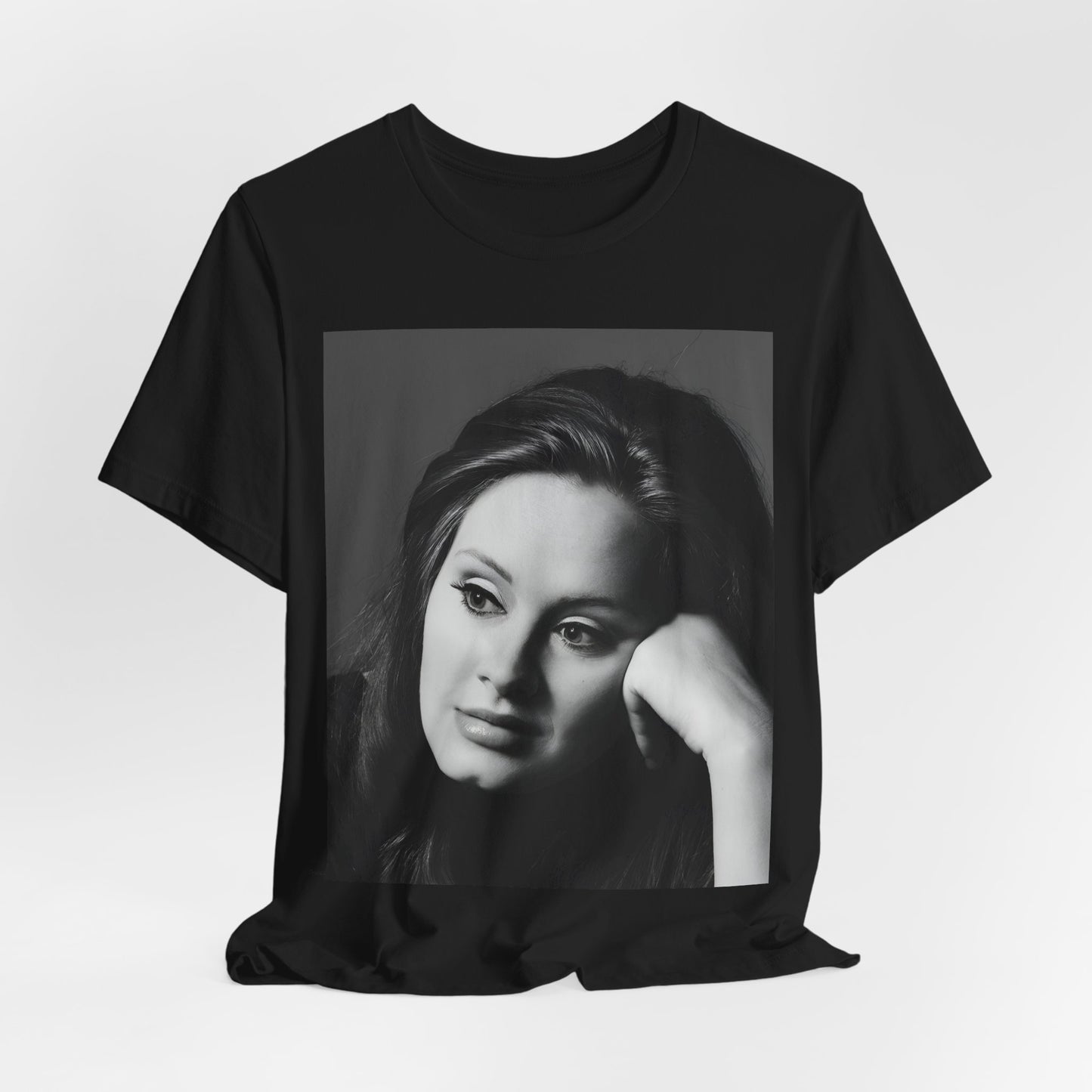 A black graphic t-shirt featuring a vintage-style black and white studio portrait of Adele, showing her with a poised and elegant expression.