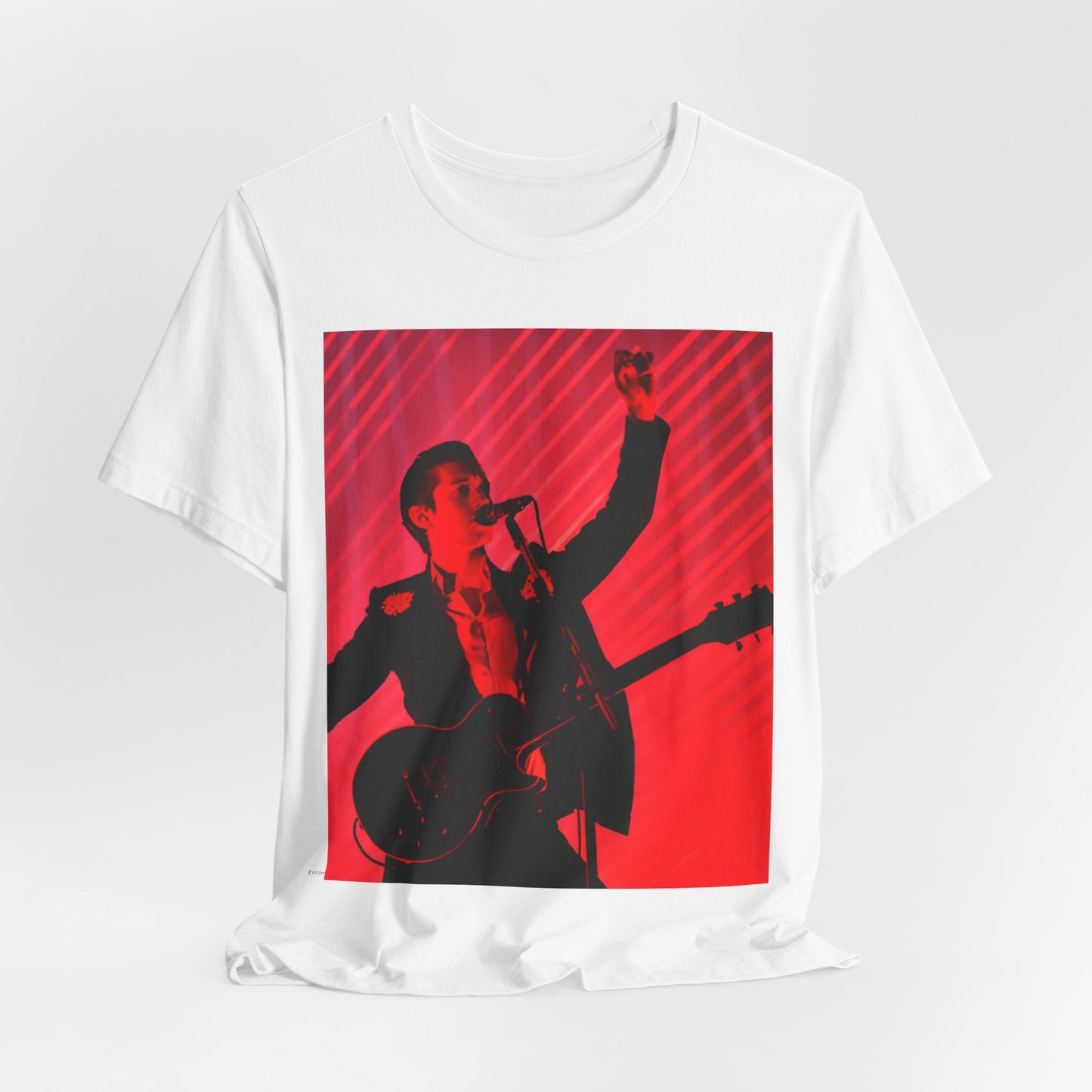 A black graphic t-shirt featuring a dynamic graphic or photo of Arctic Monkeys performing live in concert.