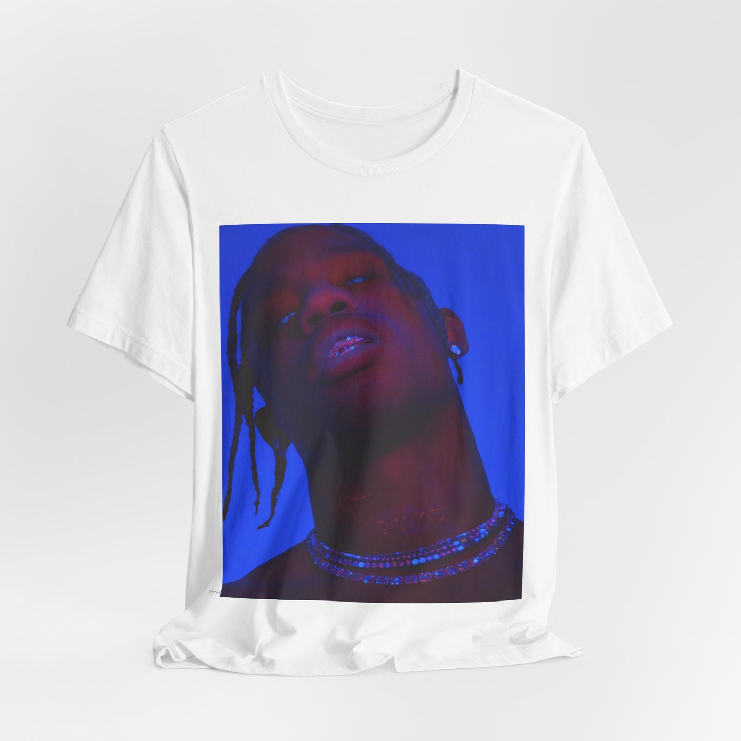 A black graphic t-shirt featuring a bold graphic of Travis Scott as a rap superstar.