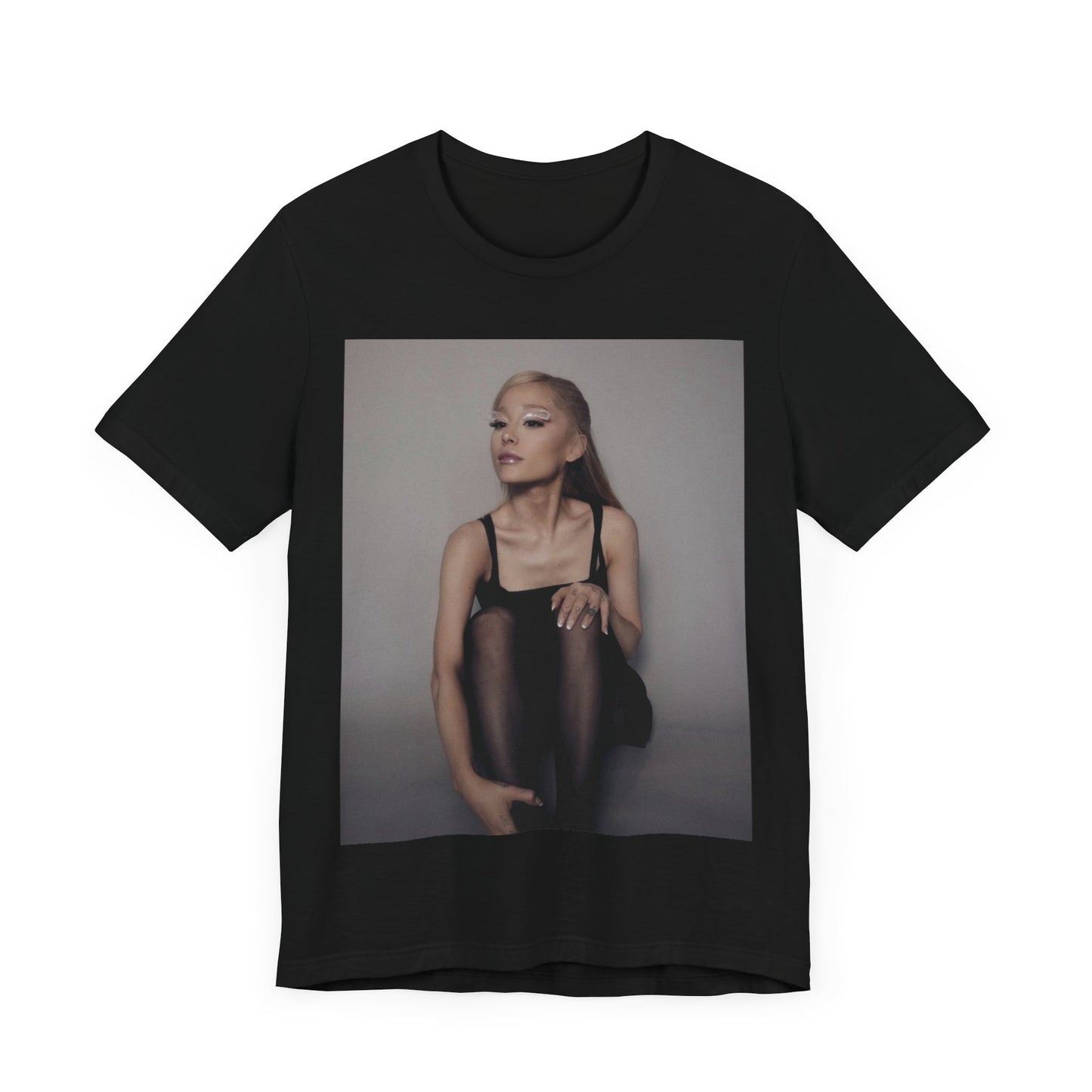 A black graphic t-shirt featuring a bold and beautiful graphic of Ariana Grande, emphasizing her strong and confident presence.